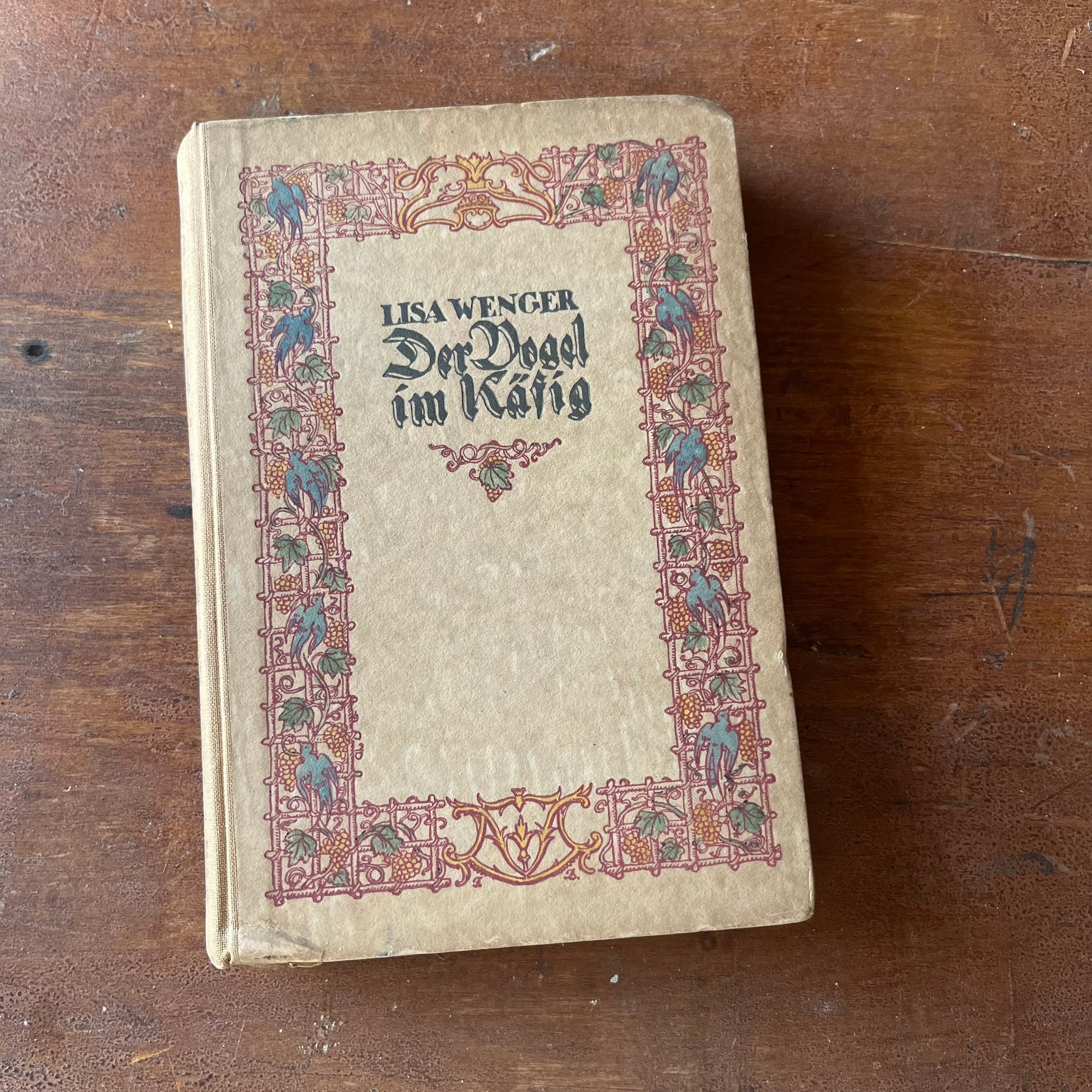 Der Vogel im Kafig (The Bird in the Cage) by Lisa Wenger-antique novel-view of the front cover with a floral design with birds in a block around the edge - the title is in the middle