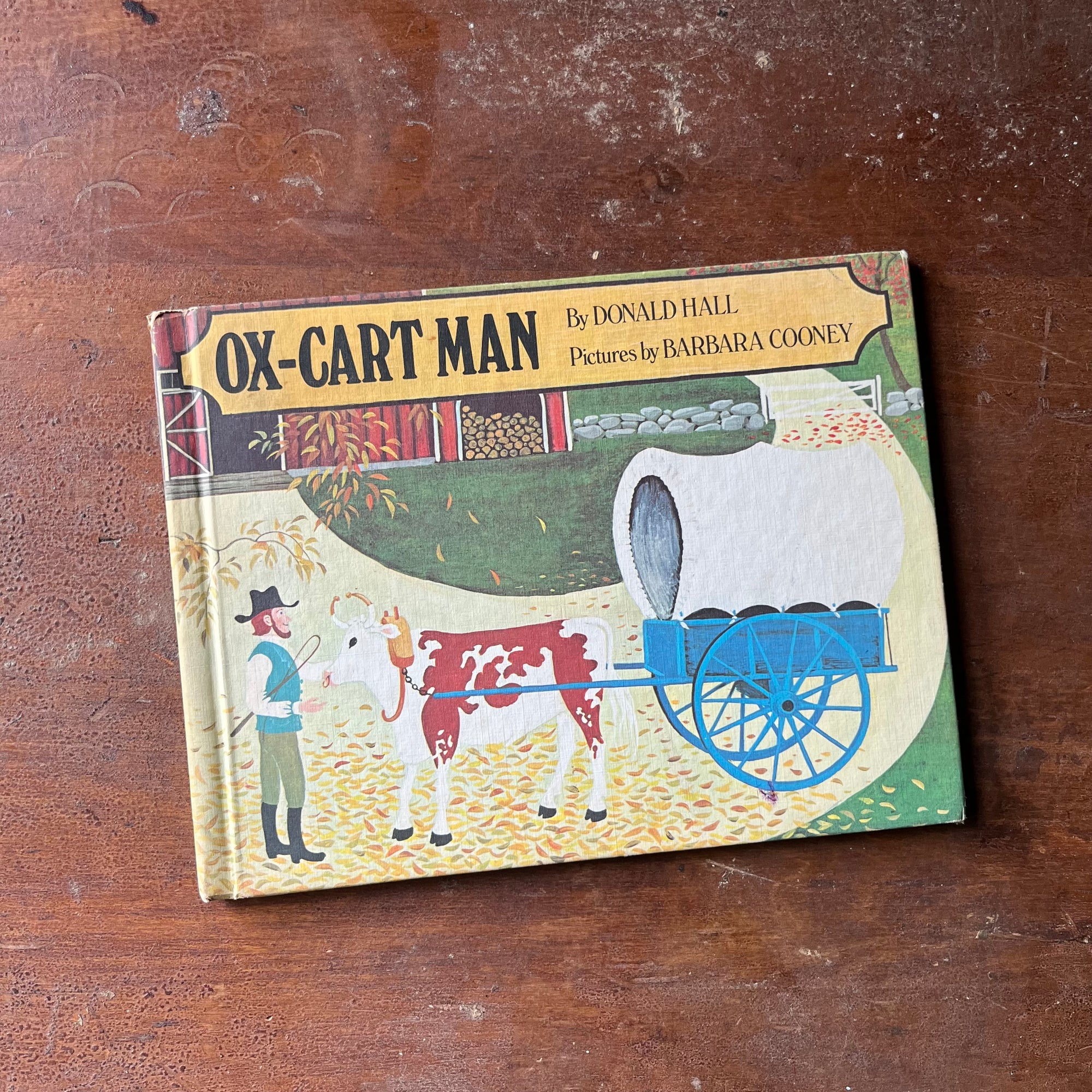 vintage children's picture book, 1980 Caldecott Medal Winner - Ox-Man Cart written by Donald Hall with illustrations by Barbara Cooney - view of the front cover with an illustration of the Man & is ox & cart