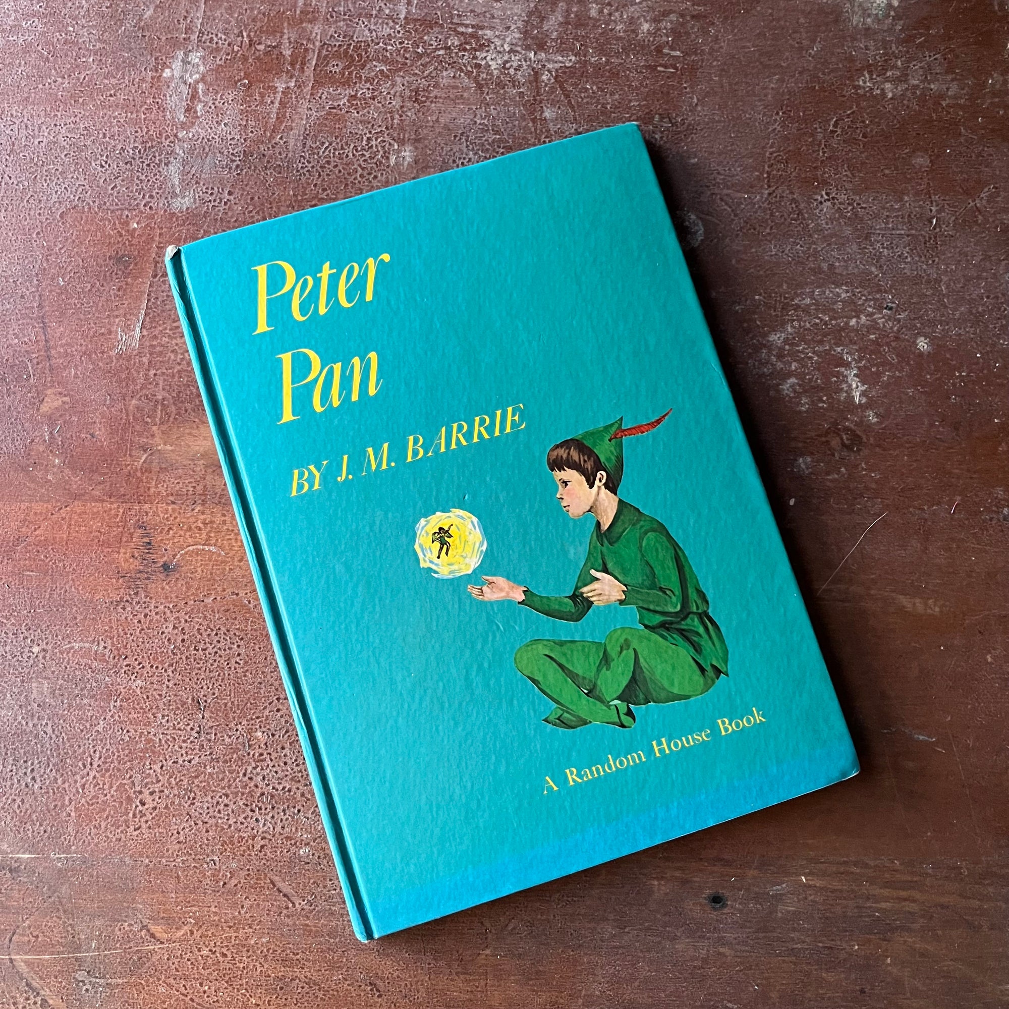 Peter Pan by J. M. Barrie with illustrations by Marjorie Torrey-A 1957 Random House Book-view of the front glossy cover with an illustration of peter pan & tinker bell with a turquoise blue background