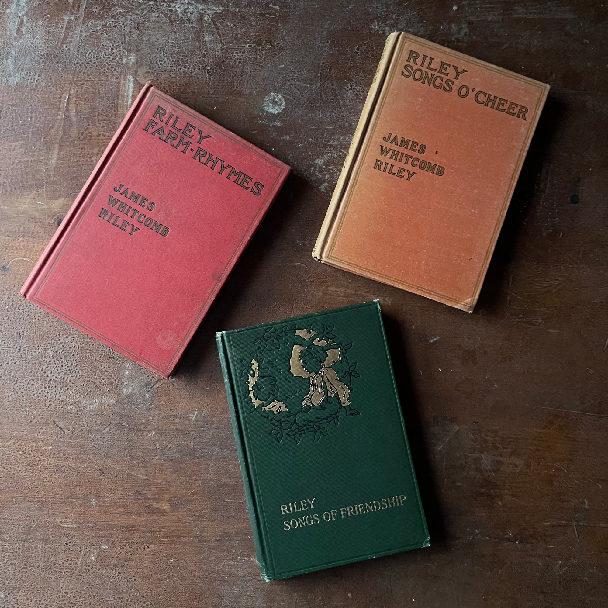 Set of Three Poetry Books written by James Whitcomb Riley:  Riley Songs of Friendship, Riley Songs O' Cheer & Riley Farm-Rhymes - view of the embossed front covers in different colors