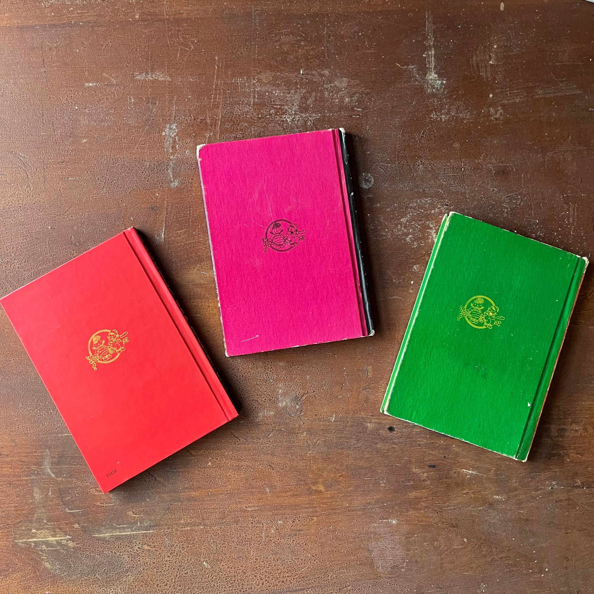 Set of Three Raggedy Ann Books by Johhny Gruelle-Raggedy Ann Stories, Raggedy Ann & Andy & the Camel with the Wrinkled Knees & Raggedy Ann and the Wonderful Witch-view of the back covers in red, pink & green