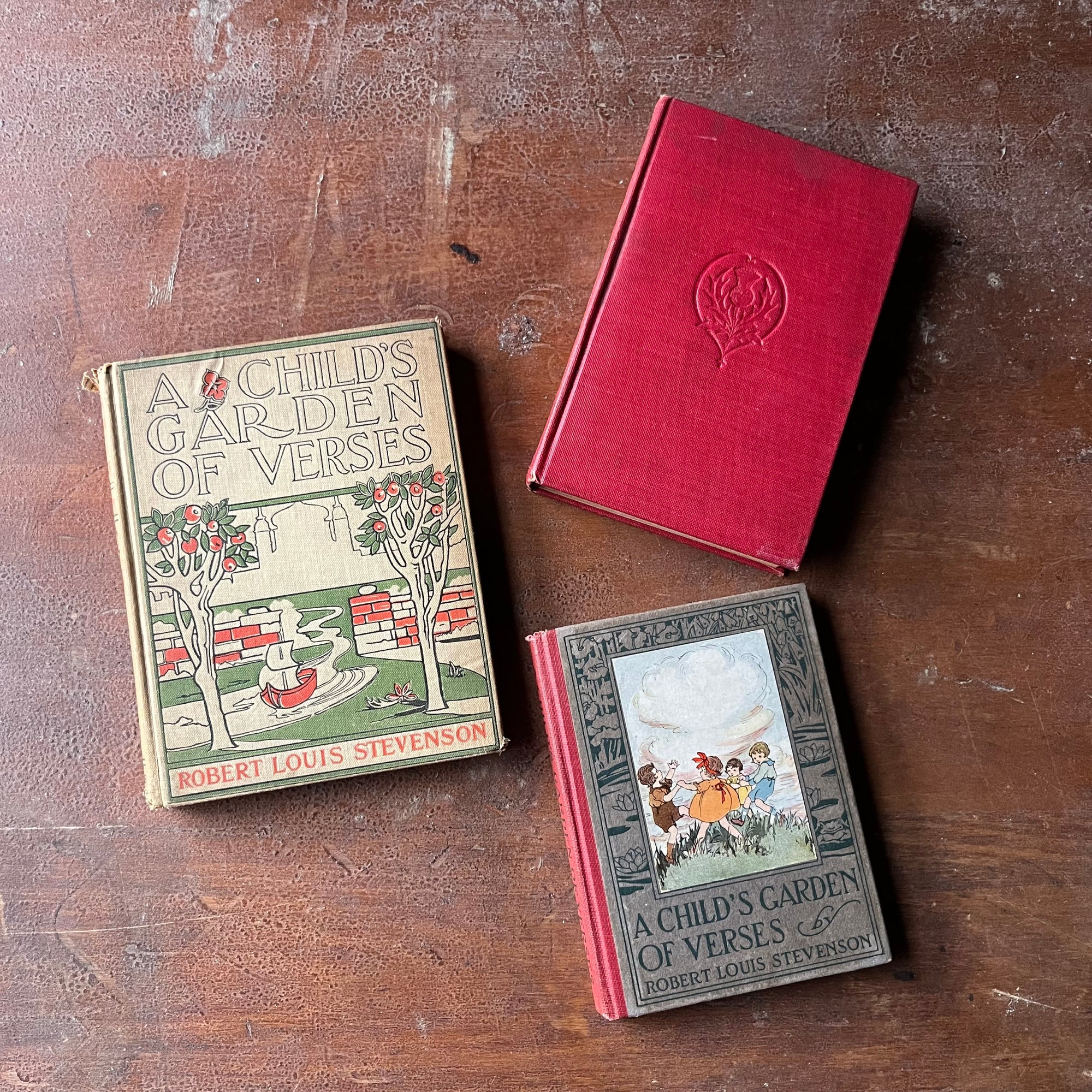 Set of Three Robert Louis Stevenson's A Child's Book of Verses-vintage children's poetry books - view of the book's front covers - two are decorated & one is plain red.