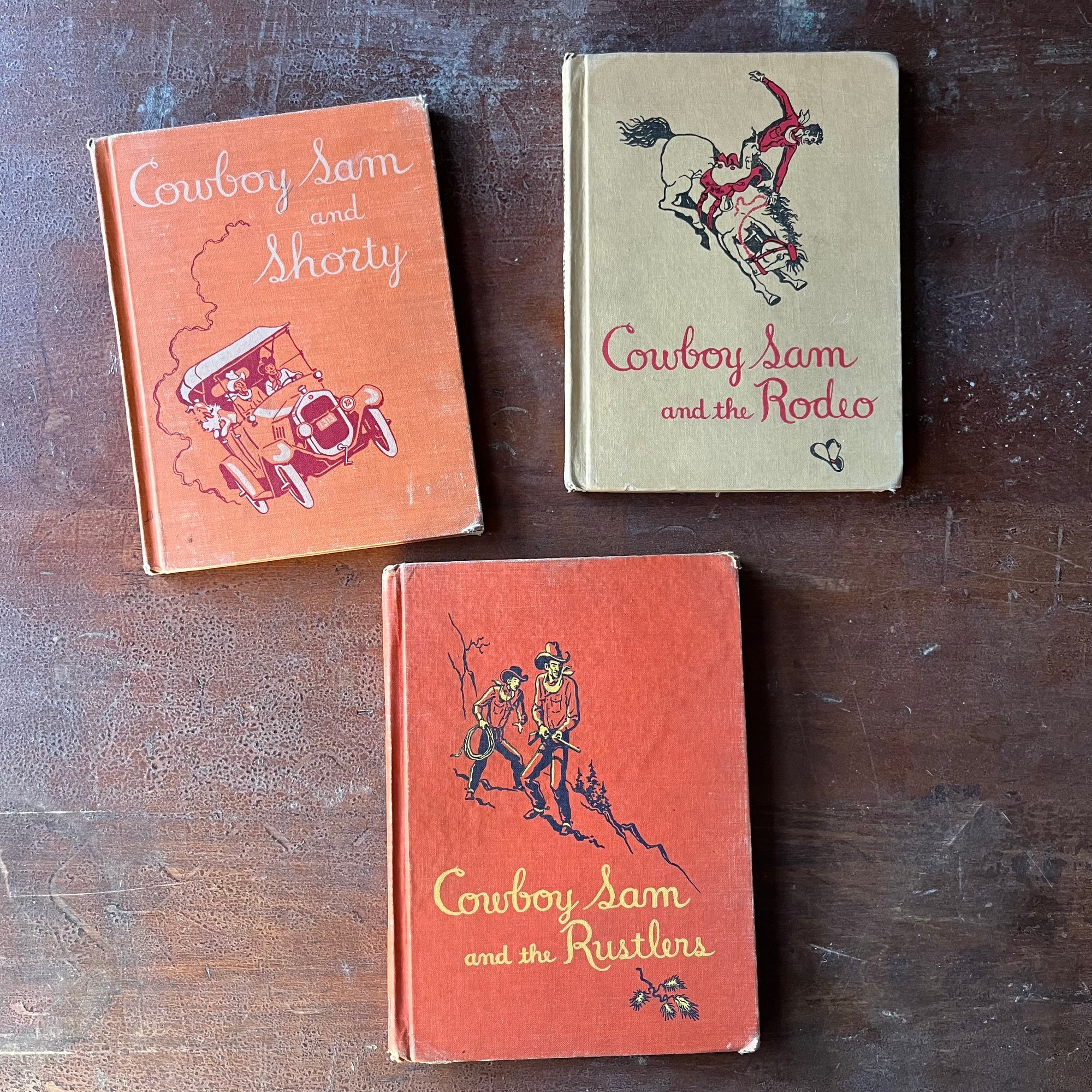 vintage children's early readers - Set of Three Vintage Cowboy Sam Books-Cowboy Sam & the Rodeo, Cowboy Sam & the Rustlers & Cowboy Sam and Shorty written by Edna Walker Chandler with illustrations by Jack Merryweather - view of the front covers with the title of each book in a decorative font & an illustration from each story