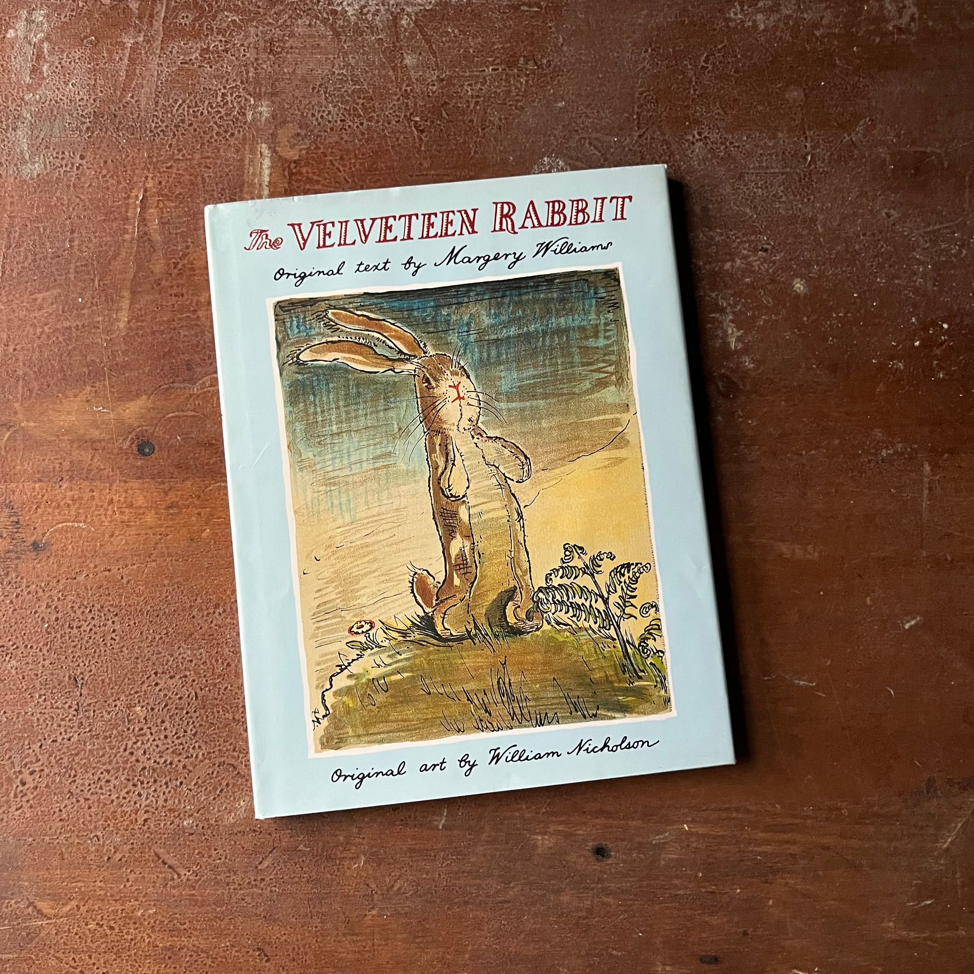 The Velveteen Rabbit written by Margery Williams with illustrations by William Nicholson-1991 Edition-vintage children's picture book-view of the dust jacket's front cover in light blue with an illustration of the Velveteen Rabbit on the cover