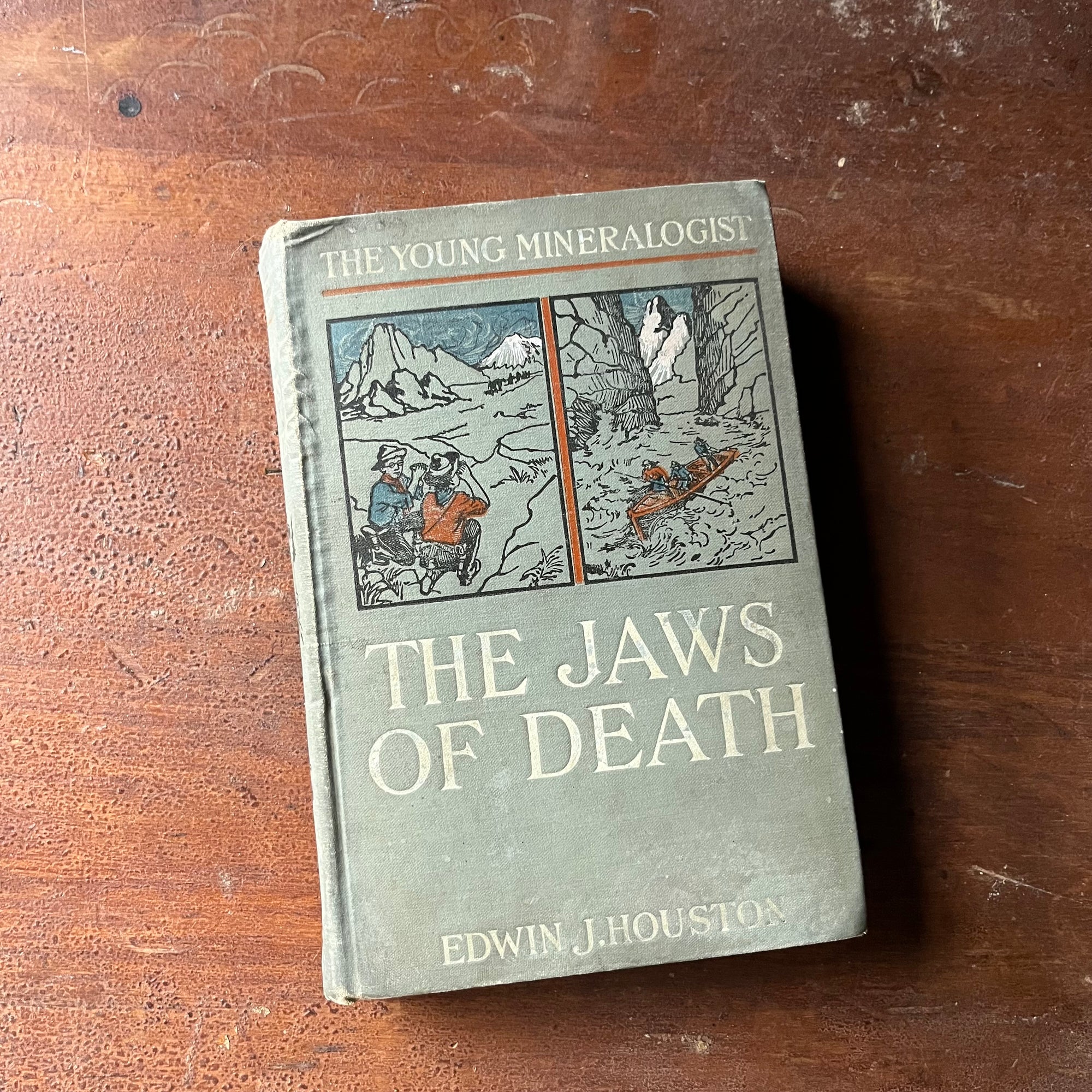 vintage children's chapter book, adventure books for boys - The Young Mineralogist: The Jaws of Death written by Edwin J. Houston - view of the embossed front cover with two illustrations one in the mountains & one going downriver in a canoe