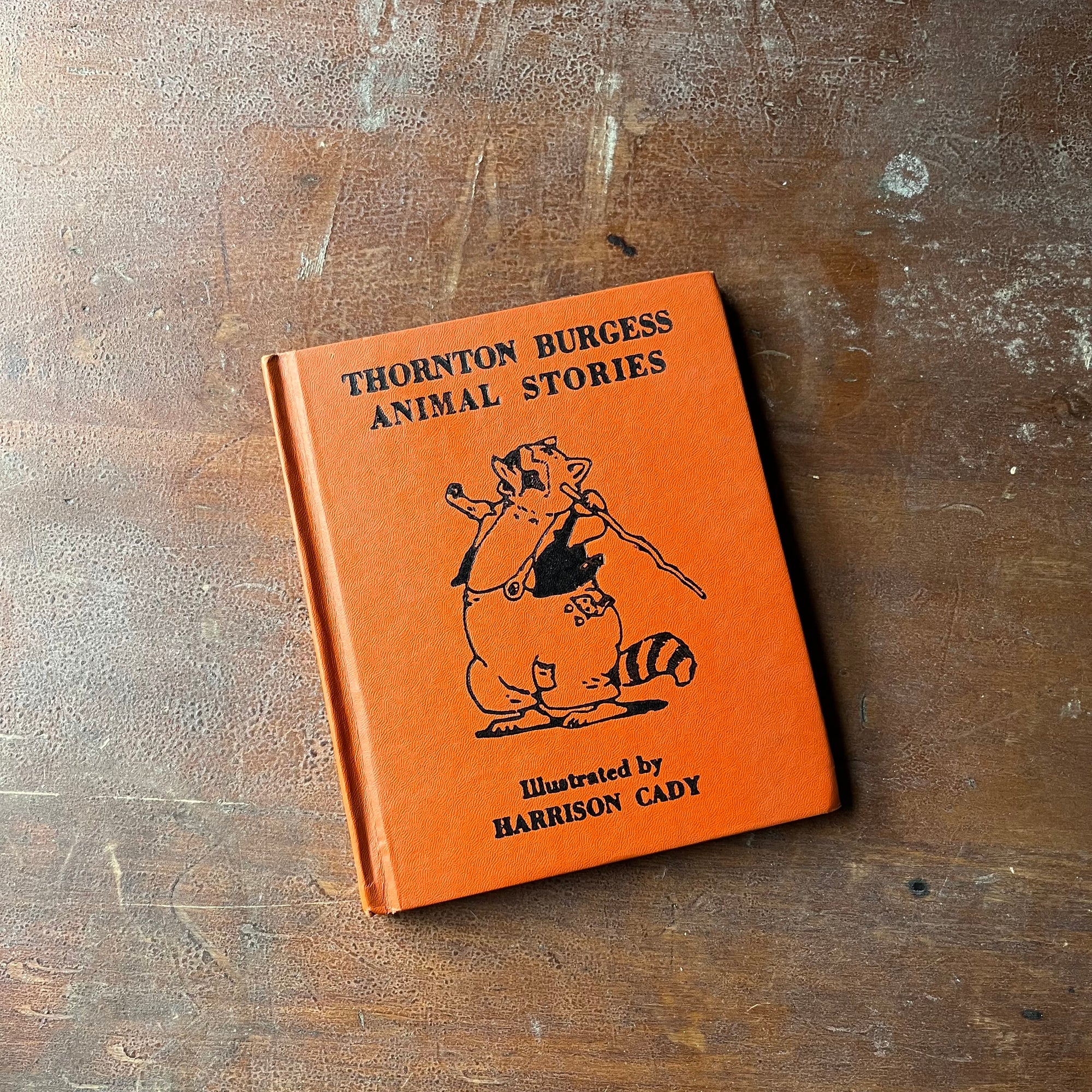 Thorton Burgess Animal Stories with illustrations by Harrison Cady-1942 Edition-antique children's storybook-view of the embossed front cover with a raccoon on it - orange background with black embossing
