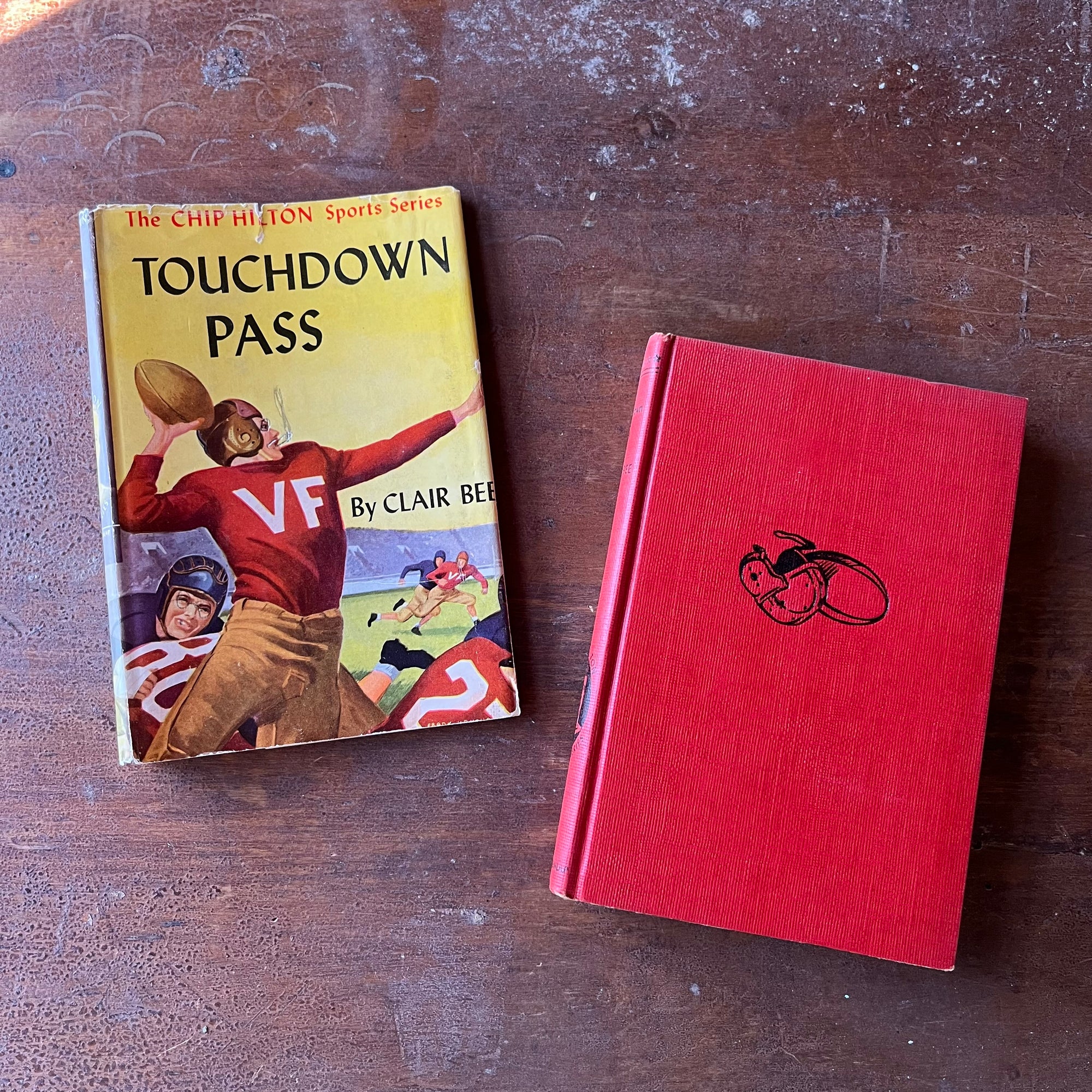 Touchdown Pass by Clair Bee-Book #1 in The Chip Hilton Sports Series Book-vintage sports book for boys-view of the red front cover with a black football helmet embossed in the middle