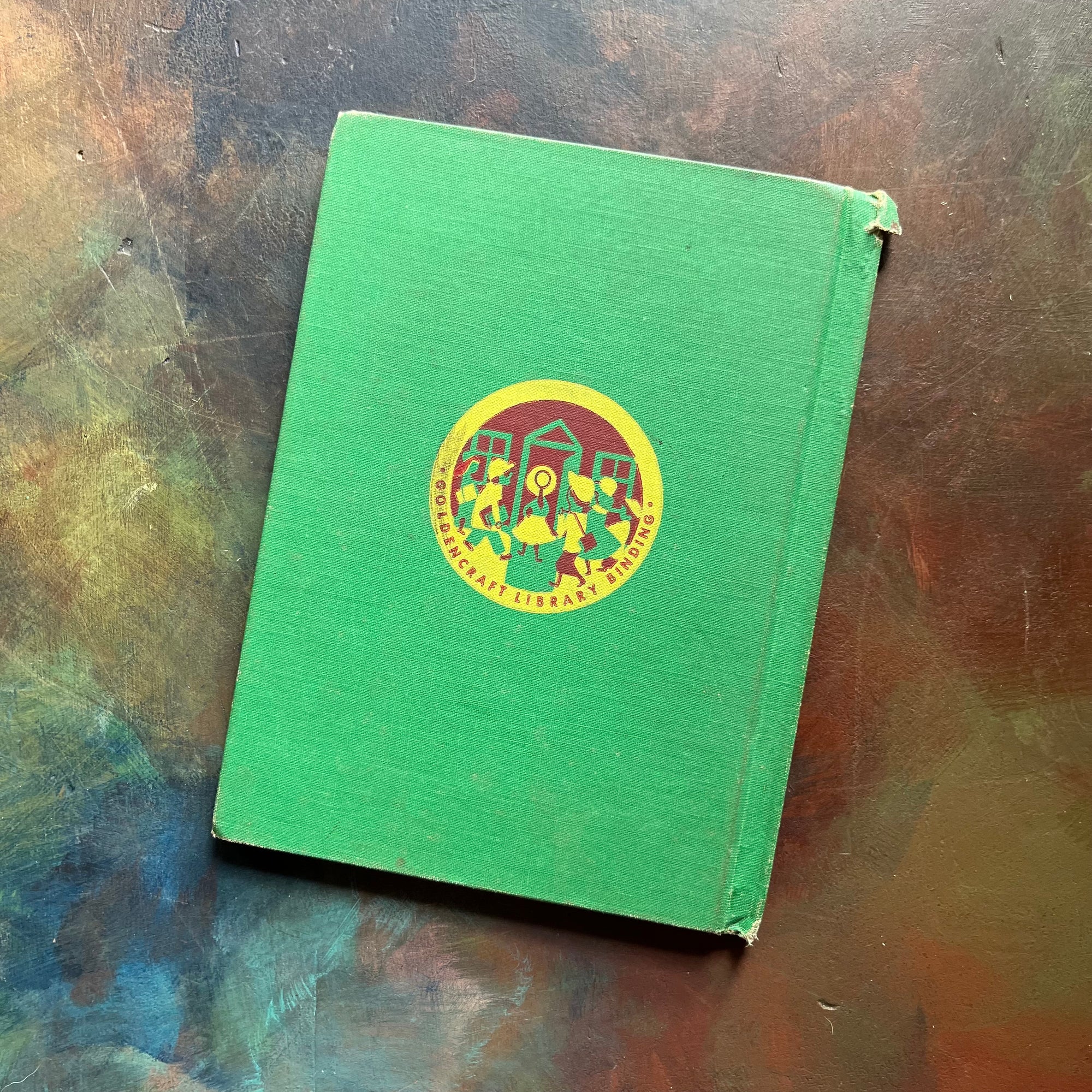 Vintage Green book titled 'Tomorrow the Moon' by Walt Disney on a textured surface-A Tomorrowland Adventure Book-Walt Disney Productions-living science book for kids-view of the back cover