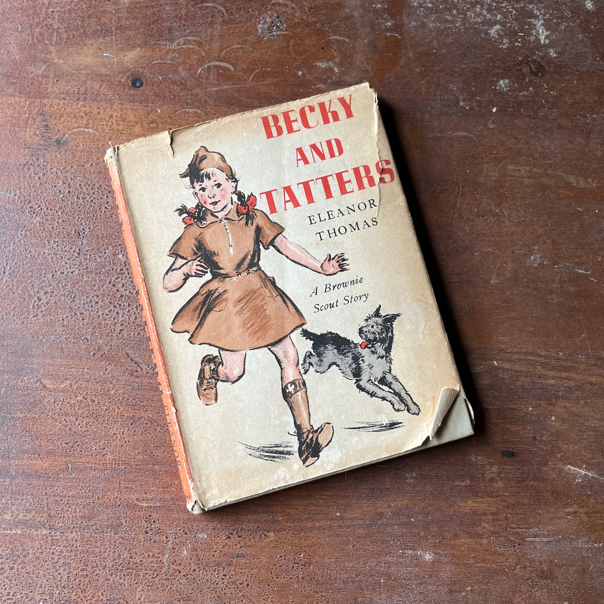 Log Cabin Vintage - vintage children's book, a brownie scout story, vintage chapter book - Beck and Tatters:  A brownie Scout Story written by Eleanor Thomas with illustrations by Gertrude Howe - view of the dust jacket's front cover with an illustration of Beck & Tatters running on it