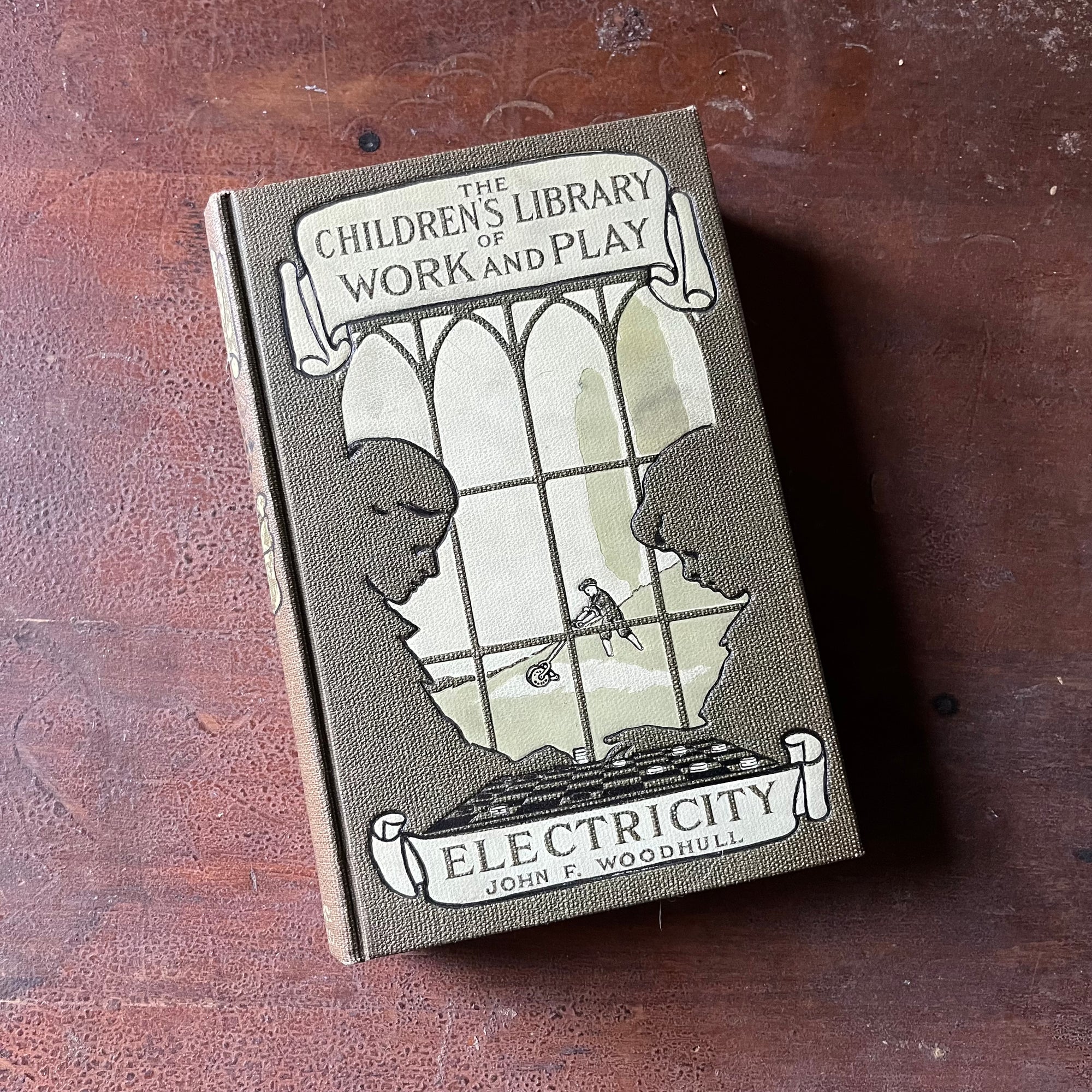 The Children's Library of Work and Play:  Electricity by John F. Woodhull - front cover view of the book sitting on a wood table
