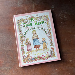 vintage children's picture book - A Time to Keep The Tasha Tudor Book of Holidays written and illustrated by Tasha Tudor - view of the front cover with three children illustrated on it with a border with all kinds of animals tucked into it