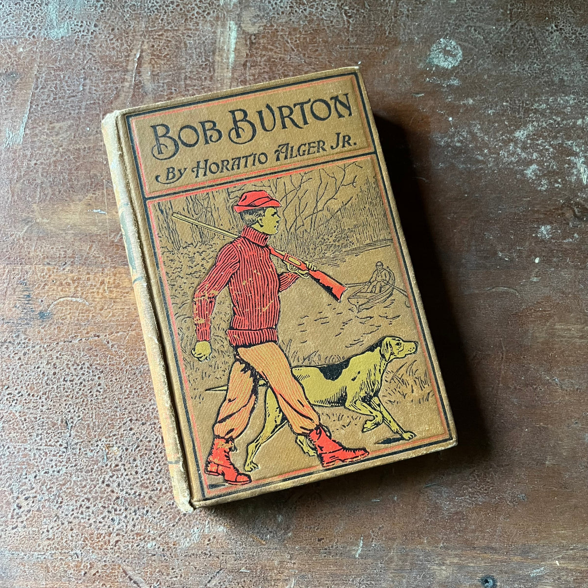 vintage children's chapter books, adventure books for boys - Bob Burton The Young Ranchman from Missouri written by Horatio Alger, Jr. - view of the embossed front cover depicting Bob Burton with a shot gun slung over his arm walking with his hunting dog