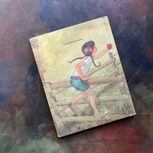 Doodlebug written and illustrated by Irene Brady was part of the vintage Weekly Reader Book Series for children transitioning from picture books to chapter books-early chapter book-view of the back cover with the main character, Jennifer, leaning over the fence holding an apple for the black stallion shown on the front cover