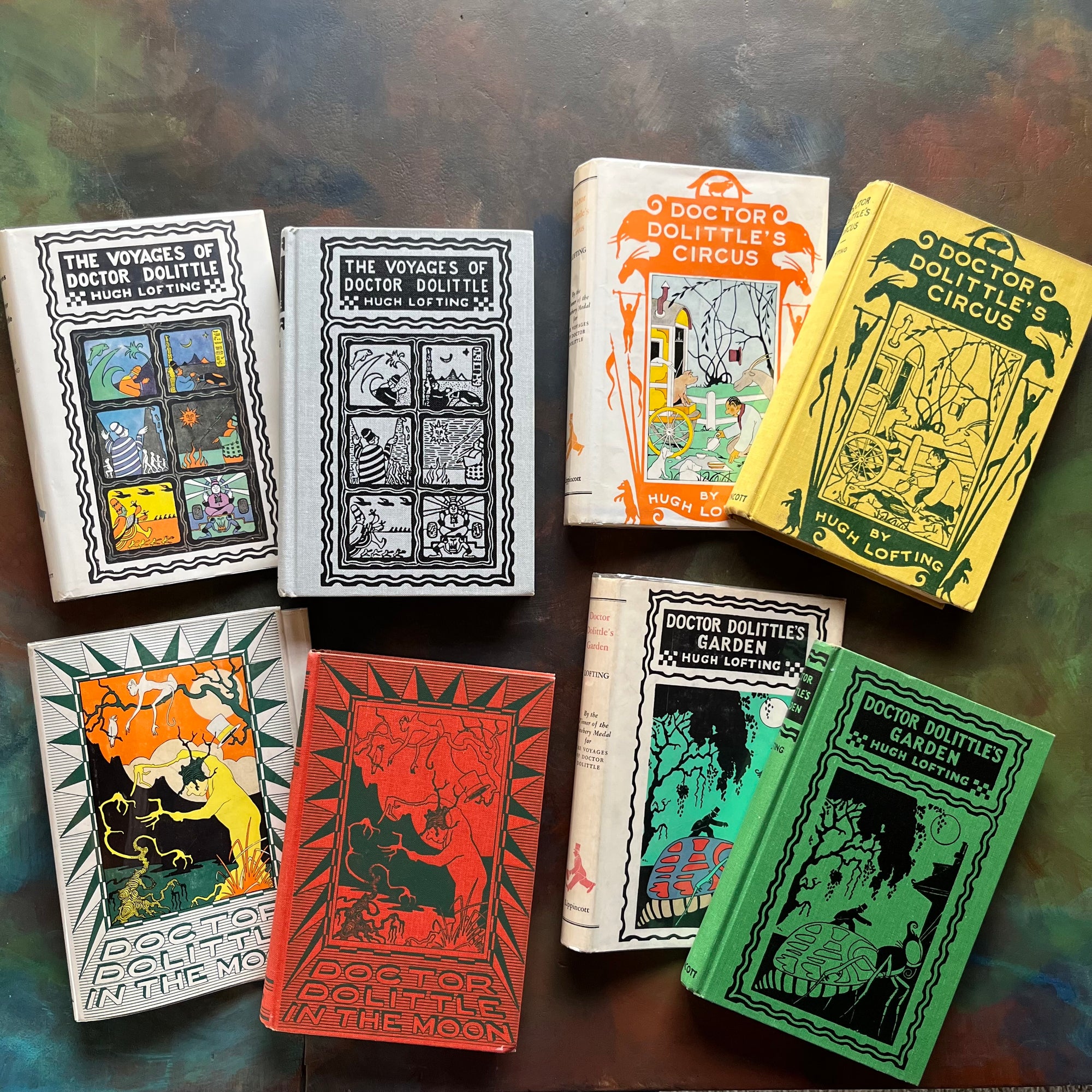 Hugh Lofting-Doctor Dolittle's Circus, Doctor Dolittle's Garden, Doctor Dolittle in the Moon and The Voyage of Doctor Dolittle-children's chapter books-view of the front covers - all in bright colors with embossed illustrations