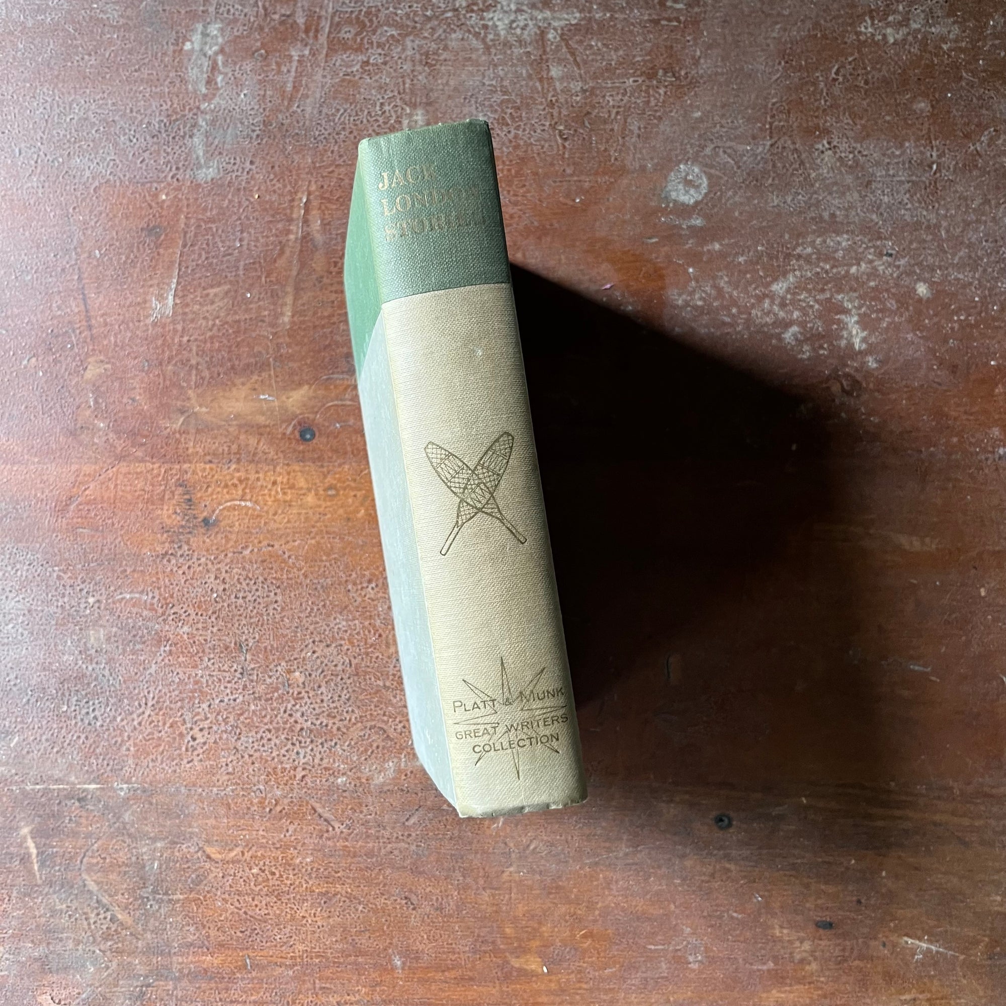 vintage children's chapter book, vintage short stories, vintage dog books - Jack London's Stories The Call of the Wild, The Cruise of the Dazzler & Other Stories of Adventure - view of the spine with a pair of snow shoes embossed on the spine