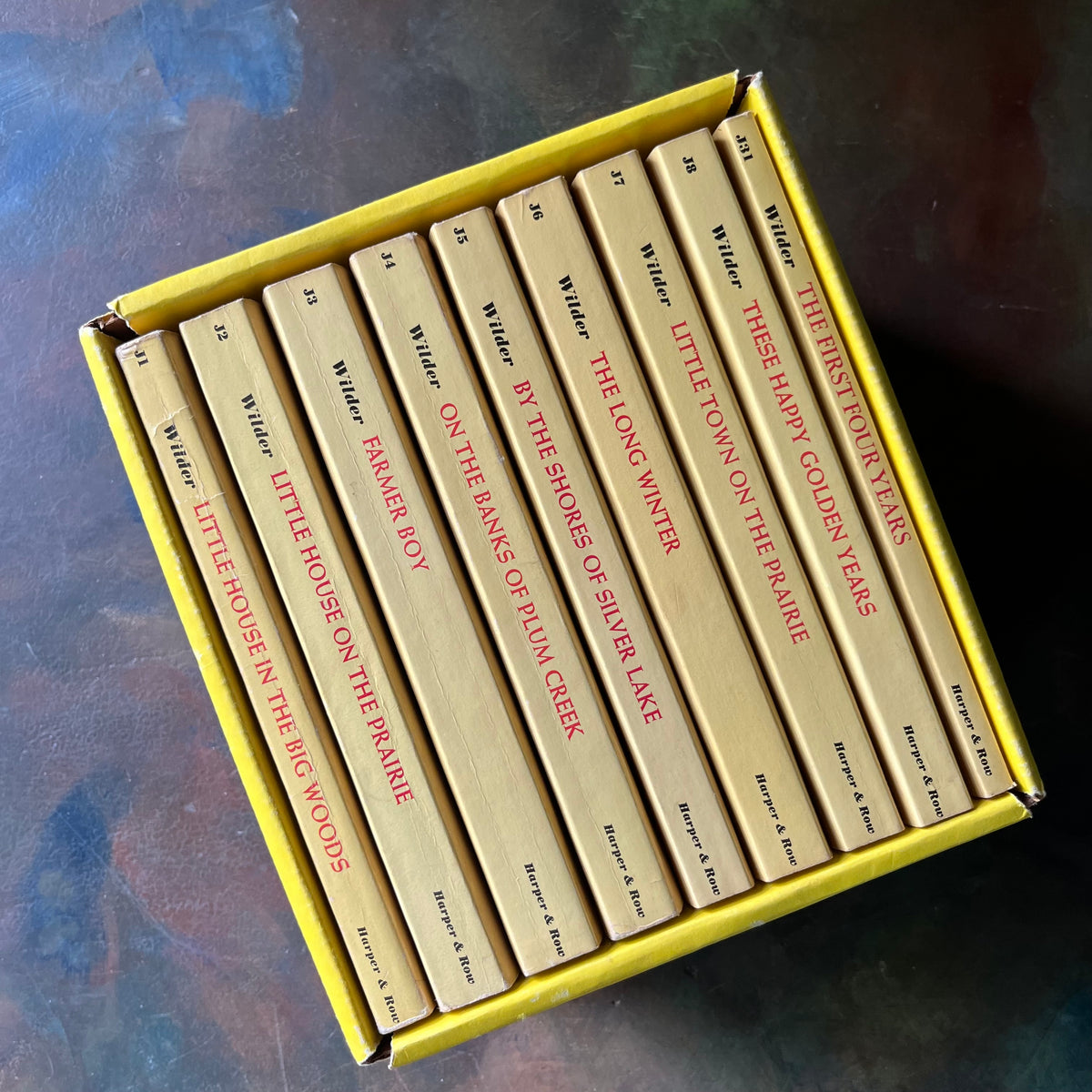 Set of books titled 'Little House on the Prairie' in a yellow box-Award-winning children's books-Laura Ingalls Wilder-view of the spines