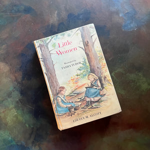 Little Women written by Louisa May Alcott with illustrations by Tasha Tudor-1969 Edition-classic American Literature-homeschool must have-classic children's literature-view of the front cover with an illustration of two girls reading in the woods