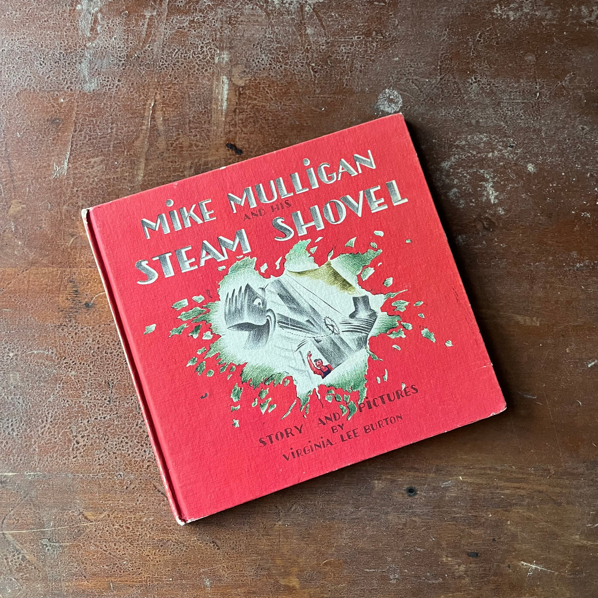 Mike Mulligan and his Steam Shovel Written & Illustrated by Virginia Lee Burton-Weekly Reader Children's Book-vintage children's picture book-view of the front cover with Mike & his steam shovel busting through the red cover