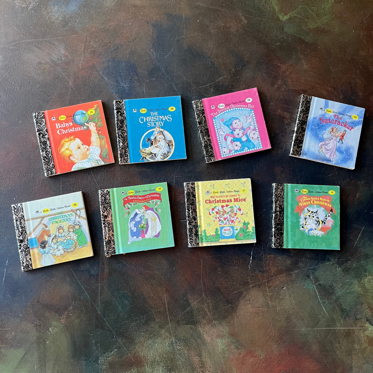 Miniature Little Golden Book Set-Christmas Editions-8 Book Set-vintage Christmas Stories-collectible children's books-view of the front covers of each book: Baby's Christmas, The Christmas Story, The Littlest Christmas Elf, The Nutcracker, The Christmas Pageant, The Twelve Days of Christmas (A Christmas Carol), Richard Scarry's Christmas Mice, and The Curious Little Kitten's First Christmas