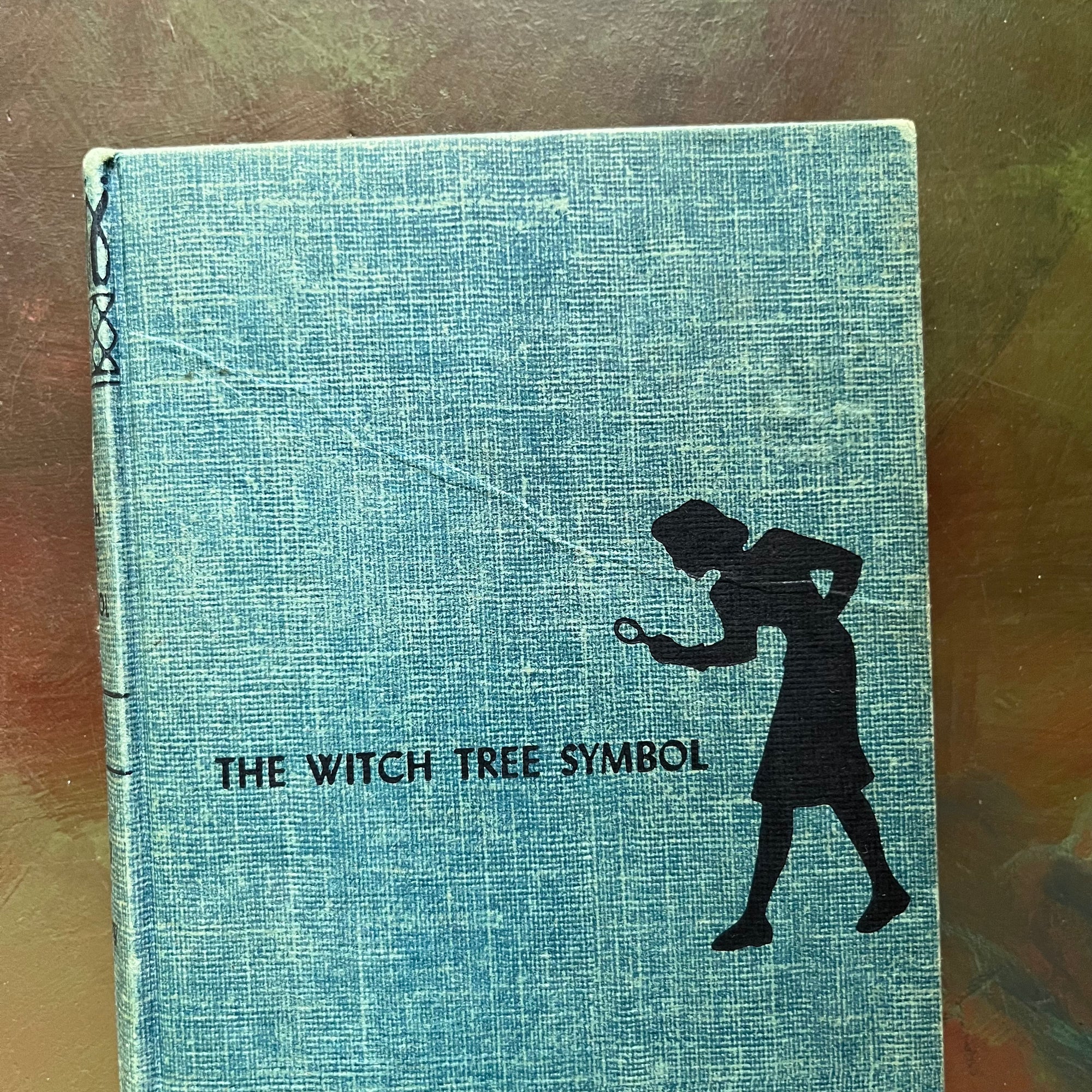 The Clue of the Broken Locket, The Clue in the Old Album, The Clue of the Leaning Chimney & The Witch Tree Symbol-view of the crease in the front cover of The Witch Tree Symbol