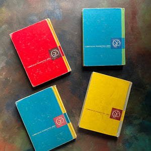 Four vintage New Basic Readers published by Scott, Foresman and Company Publishers as part of the Curriculum Foundation Series arranged in a square on a textured dark brown background. The books feature red, yellow, and blue covers with aged, worn edges.