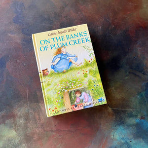 On the Banks of Plum Creek written by Laura Ingalls Wilder with illustrations by Garth Williams. This is a 1953 Edition by Harper & Row Publishers, New York & Evanston.  It was a 1938 Newbery Honor Book. 
 It is a vintage children's chapter book & living book.  View of the front cover.