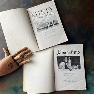 Pair of Margeurite Henry Horse Books-Misty of Chincoteague-King of the Wind-Newbery Award Book-vintage children's horse stories-view of the title pages - note the page folds at the bottom of both pages.