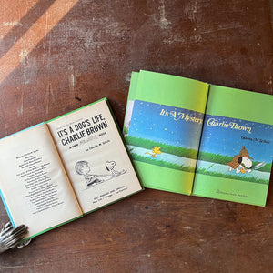  vintage children's picture books/cartoon books - Pair of vintage children's cartoon books written & illustrated by Charles M. Schulz Books for Children:  It's a Dog's Life, Charlie Brown & It's a Mystery, Charlie Brown - view of the title pages