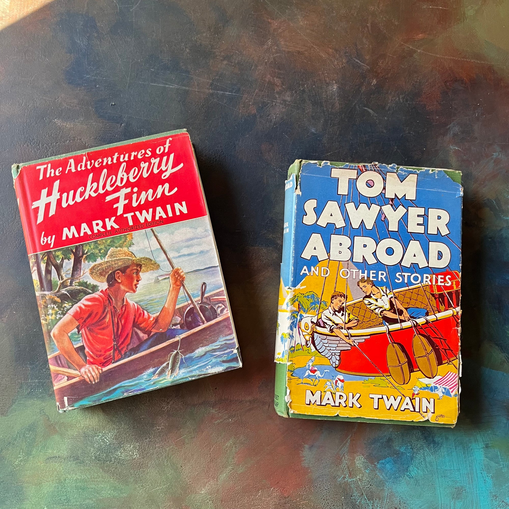 Pair of children's chapter books written by Mark Twain-The Adventures of Huckleberry Finn-Tom Sawyer Abroad & Other Stories-Grosset & Dunlap-vintage children's chapter books-view of the dust jacket's front coves