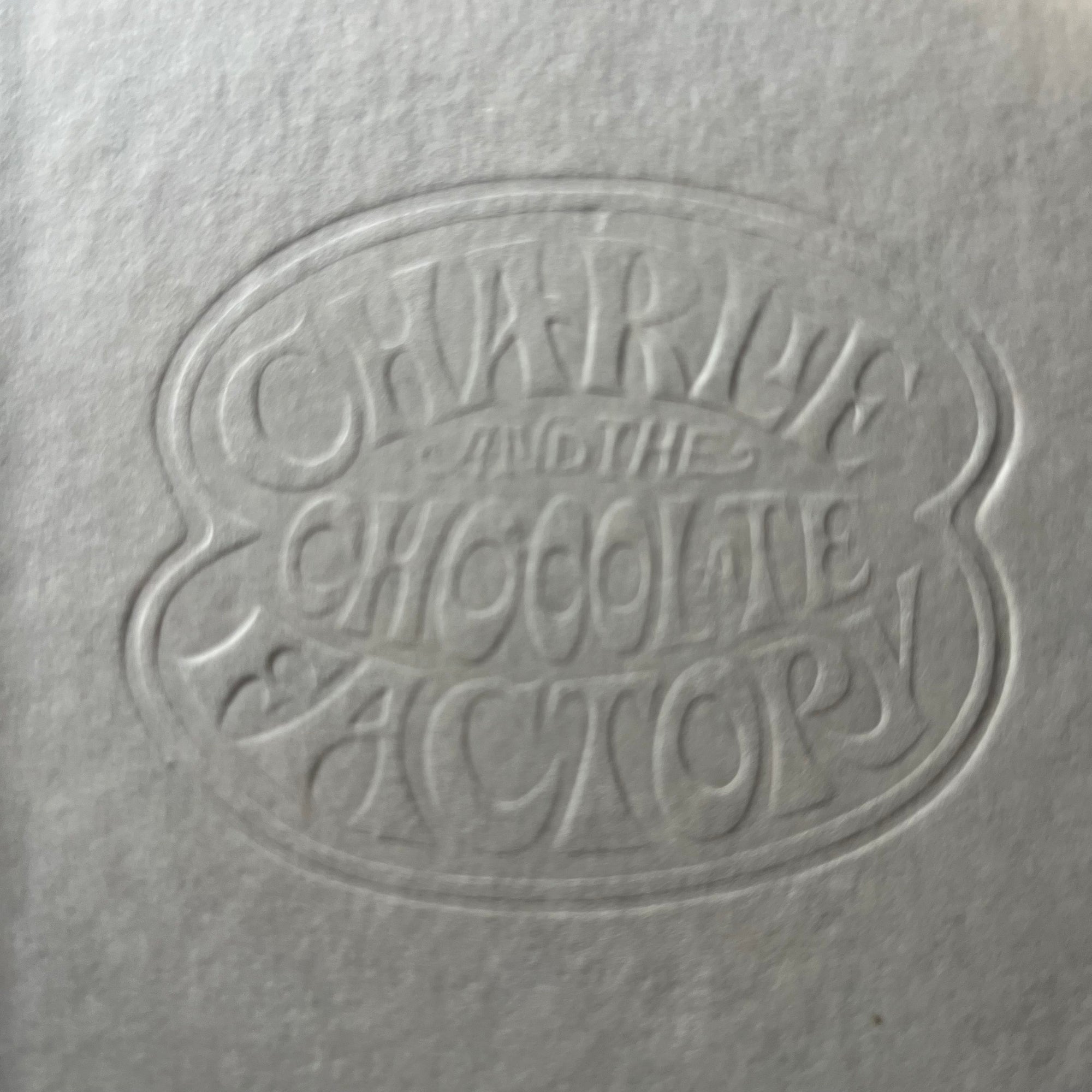 vintage children's chapter books - Pair of Roald Dahl Books-Charlie & The Chocolate Factory and Charlie & The Great Glass Elevator with illustrations by Joseph Schindelman - view of the closeup of the embossed front cover of Charlie & The Chocolate Factory showing the embossed title