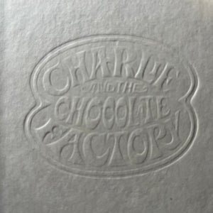 vintage children's chapter books - Pair of Roald Dahl Books-Charlie & The Chocolate Factory and Charlie & The Great Glass Elevator with illustrations by Joseph Schindelman - view of the closeup of the embossed front cover of Charlie & The Chocolate Factory showing the embossed title