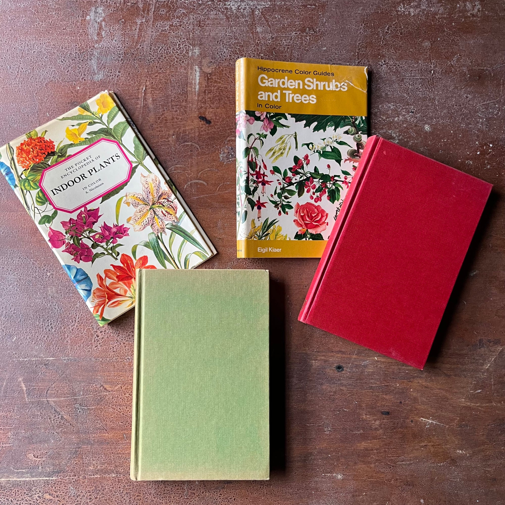 Pair of vintage plant books-Garden Shrubs & Trees and The Pocket Encyclopedia of Indoor Plants--vintage nature pocket guides-view of the front covers with the dust jackets in the background