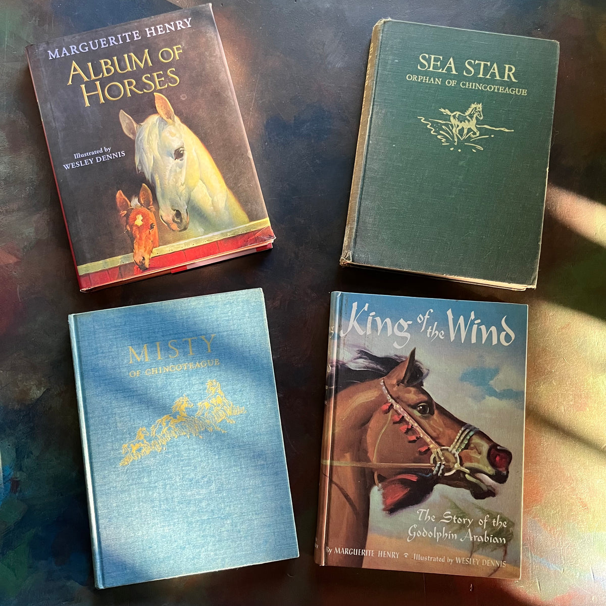 Set of Four Marguerite Henry Books-Album of Horses-King of the Wind-Sea Star-Misty of Chincoteague-vintage children's chapter books-view of the front covers showing the dust jacket of Album of Horses