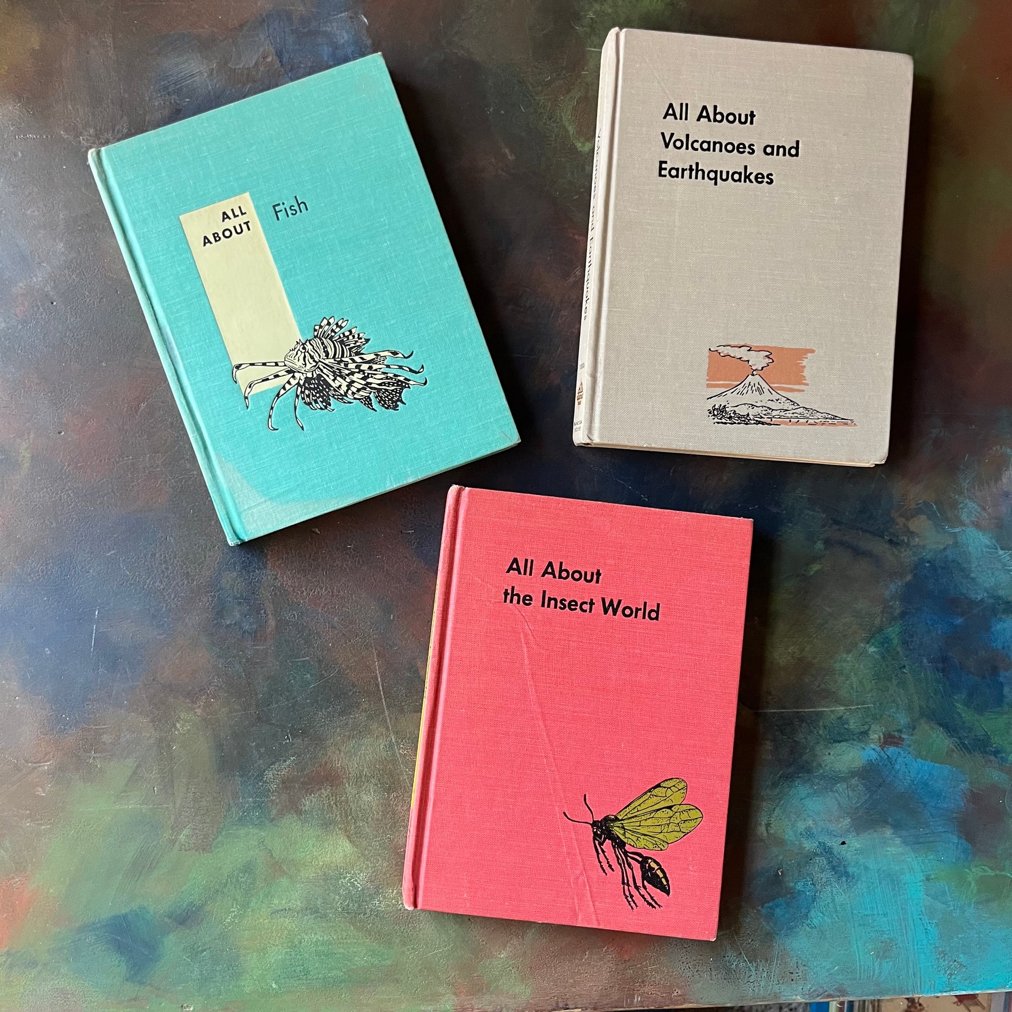 Set of Three All About Books- Volcanoes and Earthquakes-Fish-The Insect World-vintage living science books for children-vintage children's nature books-view of the front covers - note the water damage on the bottom left hand corner of Fish