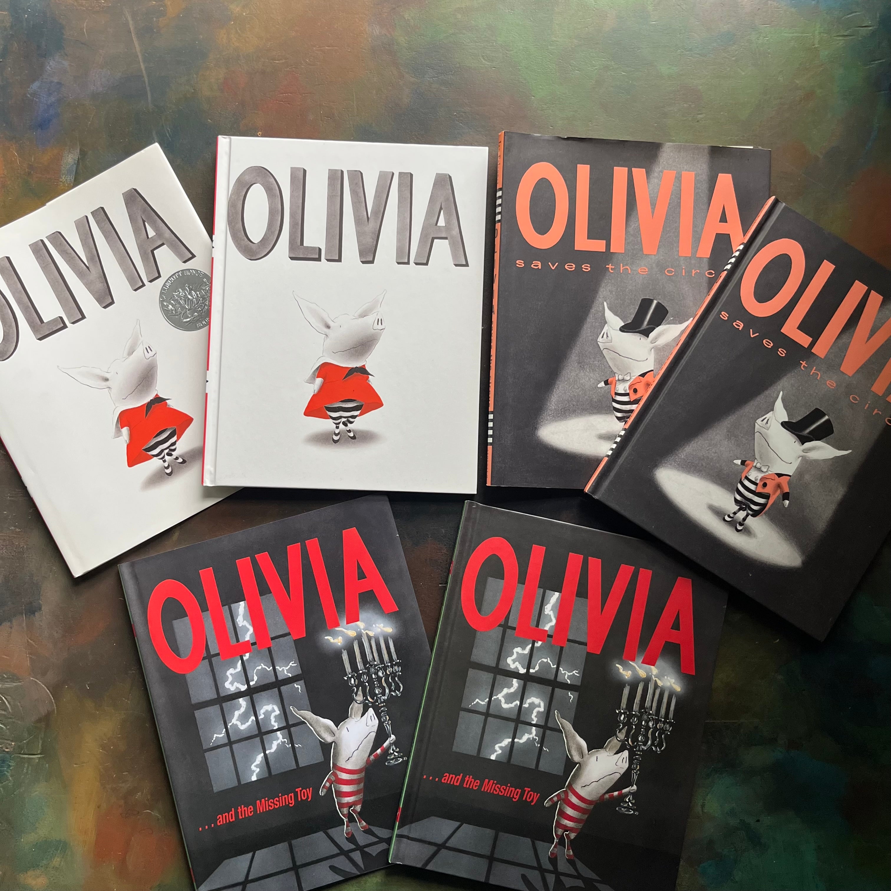 Set of Three Olivia Books written and illustrated by Ian Falconer-Olivia-Olivia Saves the Circus-Olivia and the Missing Toy-award-winning picture book-Caldecott Honor Book-view of the front covers and dust jackets with the same images on them