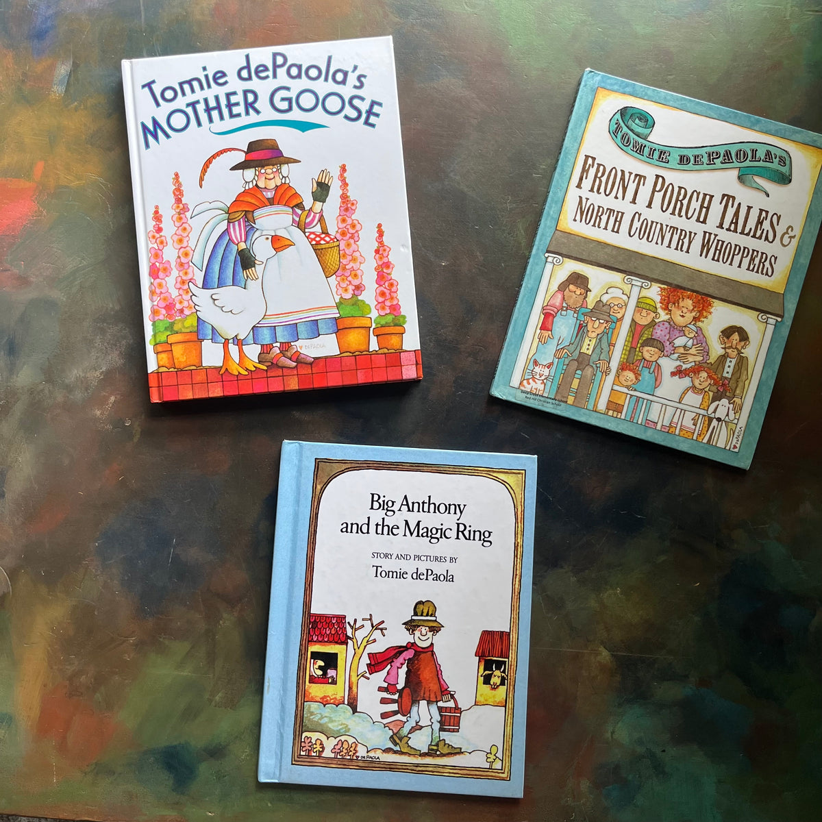 Set of Picture Books written and illustrated by Tomie DePaola -Front Porch Tales & North Country Whoppers-Big Anthony and the Magic Ring-Mother Goose-classic children's stories-view of the front covers with images from each book illustrated on the cover below the title