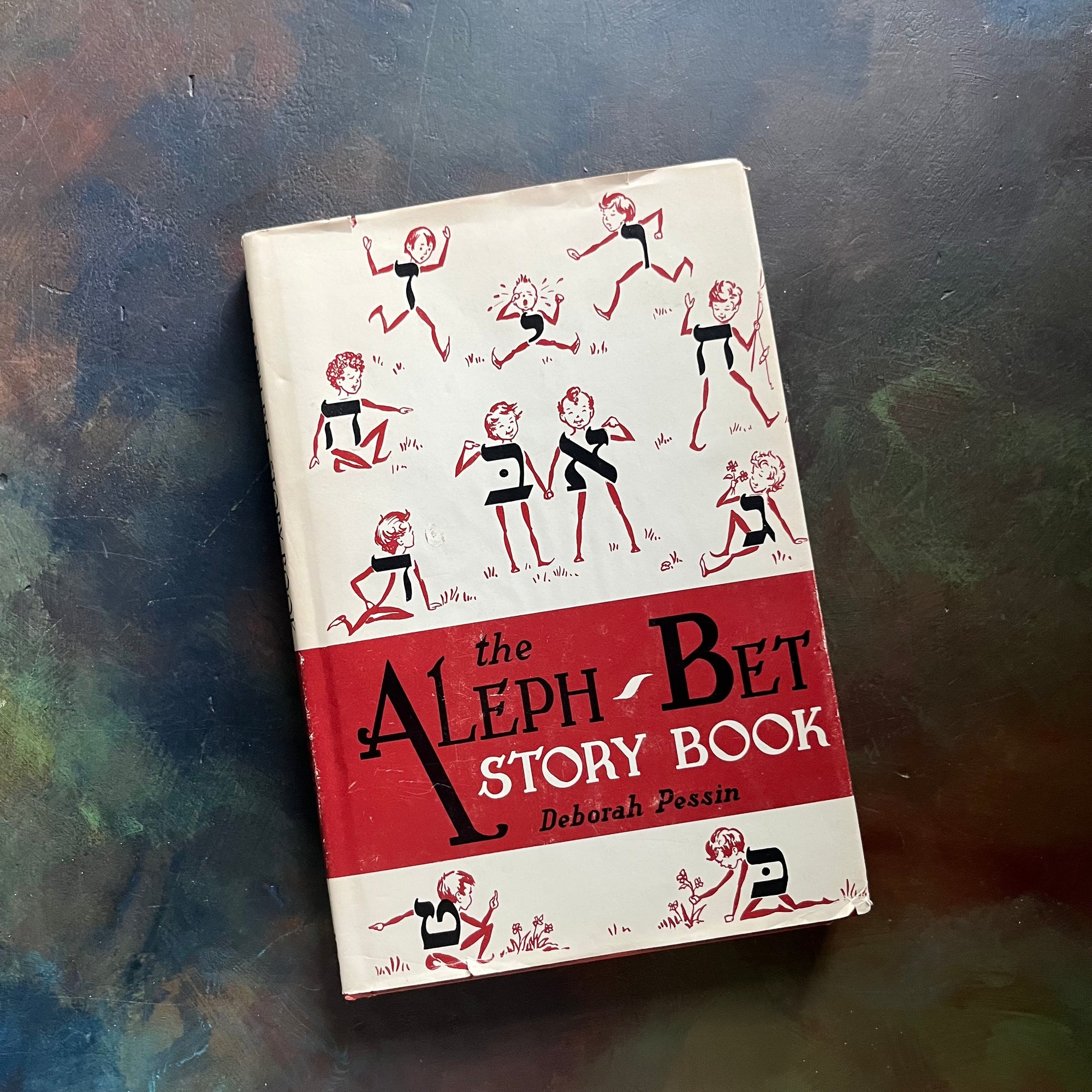 The Aleph-Bet Story Book written by Deborah Pessin-Illustrated by Howard Simon-vintage children's living book-children's Jewish Book-short stories-view of the dust jacket's front cover with illustrations of a few of the Hebrew alphabet letters turned into characters in the story.