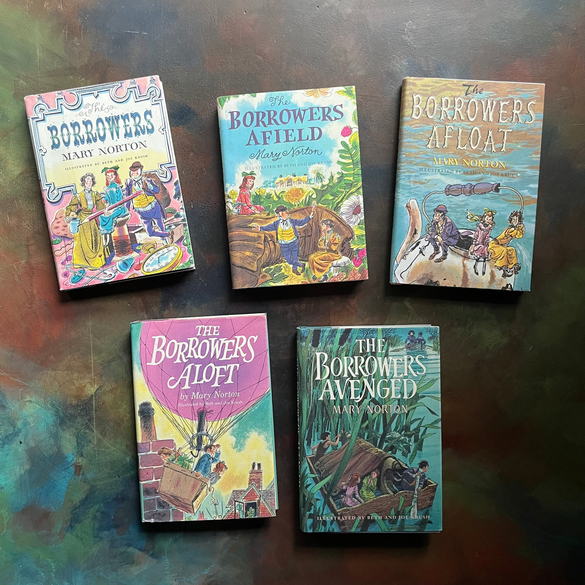 Five books from 'The Borrowers' series by Mary Norton on a textured surface-The Borrower's Complete Set written by Mary Norton-classic children's books-read aloud chapter books-view of the dust jacket's covers