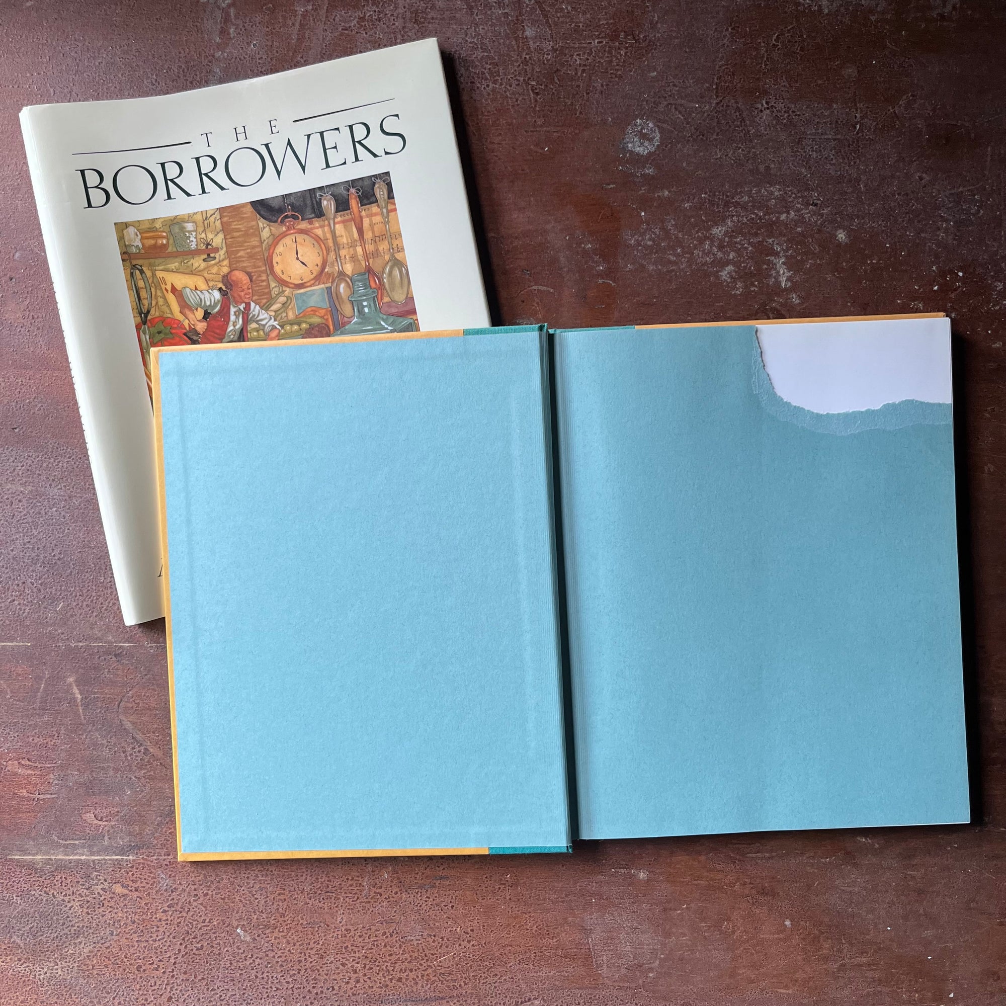 vintage children's chapter book, classic children's story, modern children's book edition - The Borrower's written by Mary Norton with illustrations by Michael Hague - view of the inside cover with the top right-hand section torn away to remove a name & address or inscription