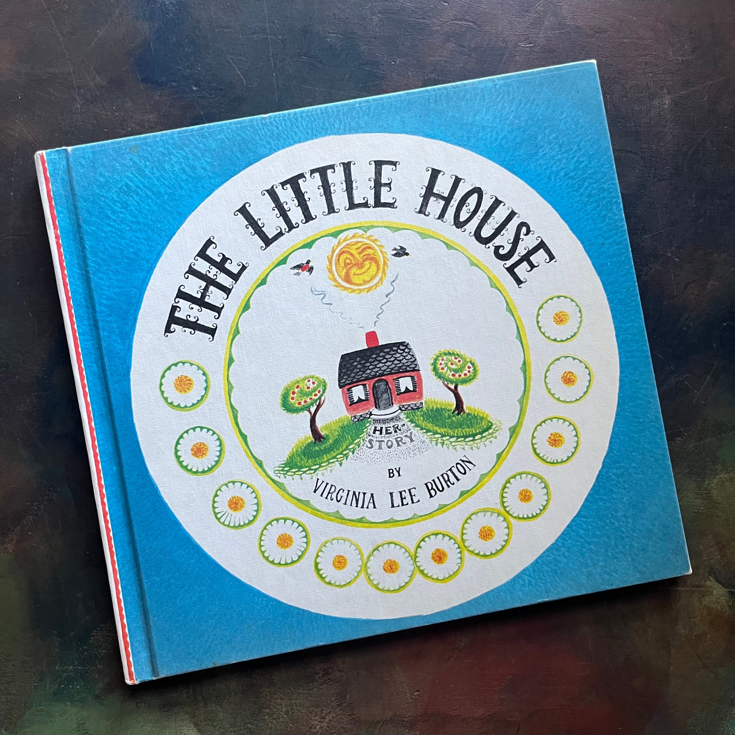 The Little House written & illustrated by Virginia Lee Burton-vintage children's picture book, Caldecott Award Winning Book-view of the front cover with an image of the little house in the middle of a circle with the title above and author name below as well as a winking sun, birds flying, and some daisies or suns there too (not sure which they are).