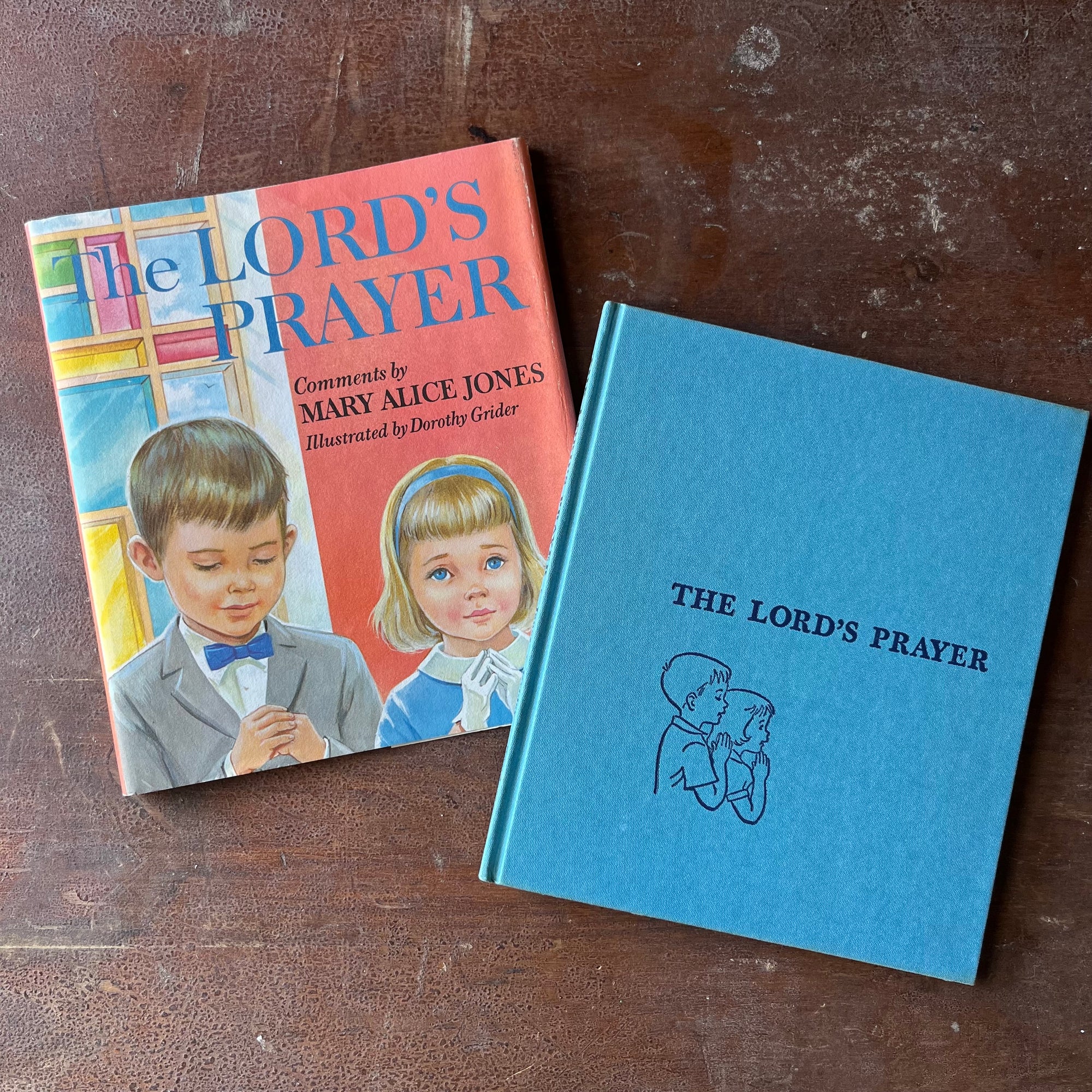 Log Cabin Vintage - vintage children's book, vintage religious book, Learning the Lord's Prayer - The Lord's Prayer Comments by Mary Alice Jones with Illustrations by Dorothy Grider - view of the embossed front cover in a beautiful shade of bright blue - two children's profile's showing them with their hands folded as though praying