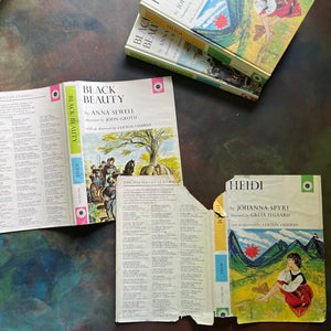 The Macmillan Classics Series-Black Beauty by Anna Sewell-Heidi by Johanna Spyri-children's classic literature-vintage children's books-view of the outside of the dust jackets showing their shabby condition with tears noted on Heidi