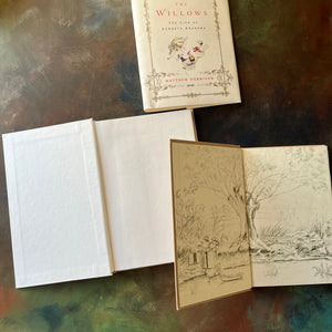 Pair of Kenneth Grahame Books: The Man in the Willows: The Life of Kenneth Grahame and The Wind in the Willows written by Kenneth Grahame & Illustrated by Tasha Tudor-view of the inside covers - Wind in the Willows has an illustration of the riverbank by Tasha Tudor with the boat and riverbank home