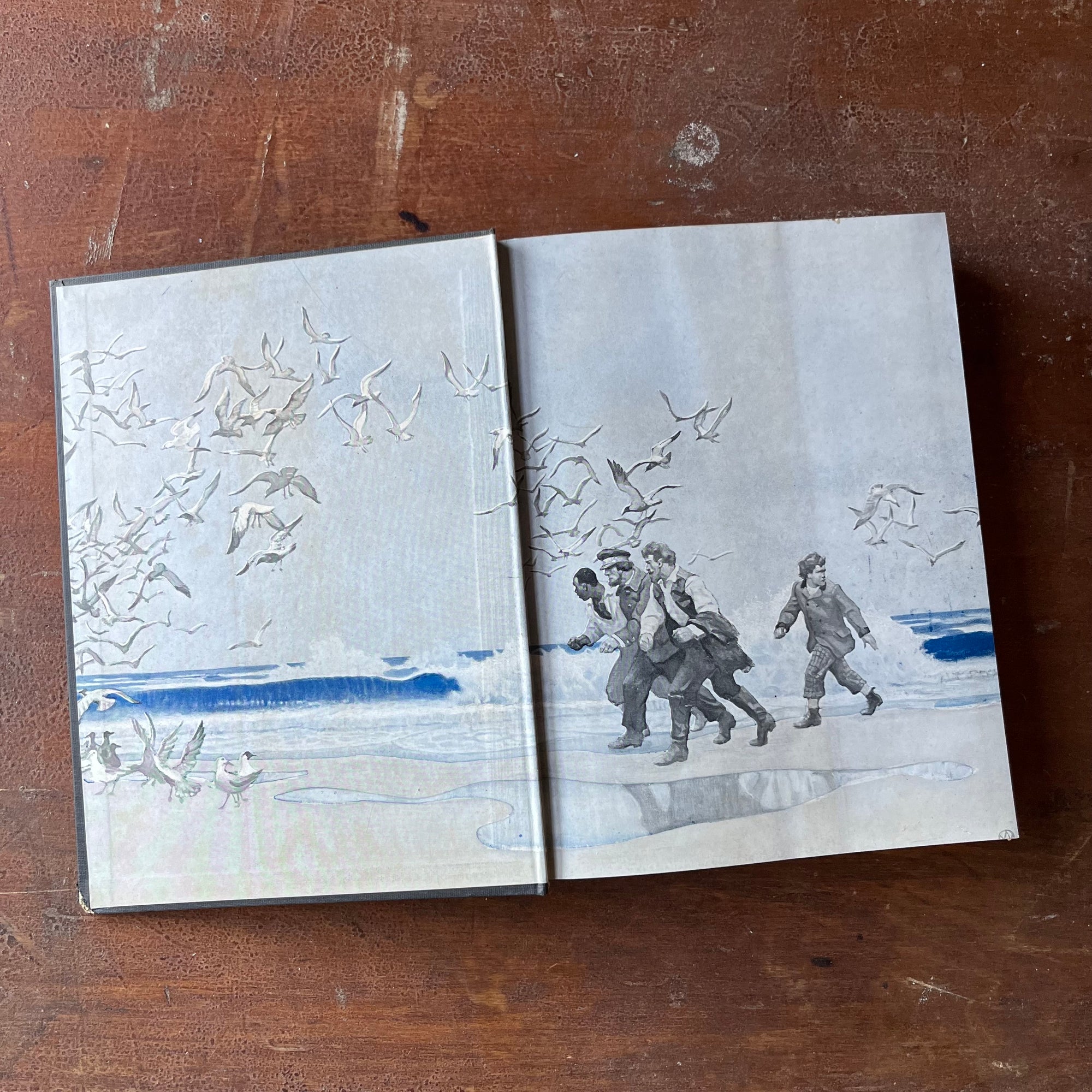 The Mysterious Island by Jules Verne with Illustrations by N. C. Wyeth-1951 Charles Scribner's Sons Edition-vintage classic children's literature-view of the inside cover with an illustration in blue, white & gray of men walking on a shore with seagulls flying up & around them