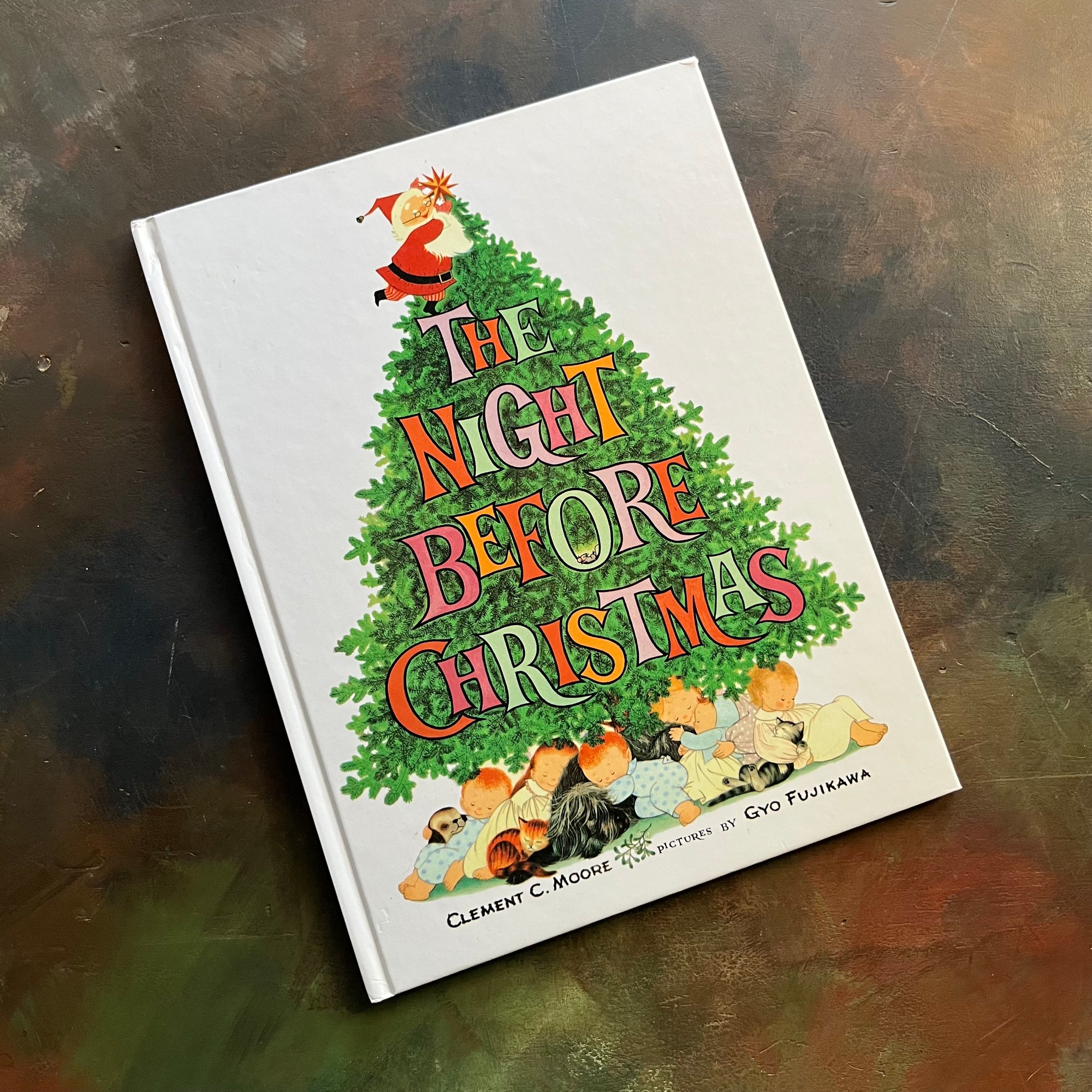 The Night Before Christmas-Clement C. Moore-Gyo Fujikawa illustrations-vintage picture book-Christmas Read Aloud-view of the front cover with a christmas tree with Santa putting a start on the stop and children and pets sleeping under the tree