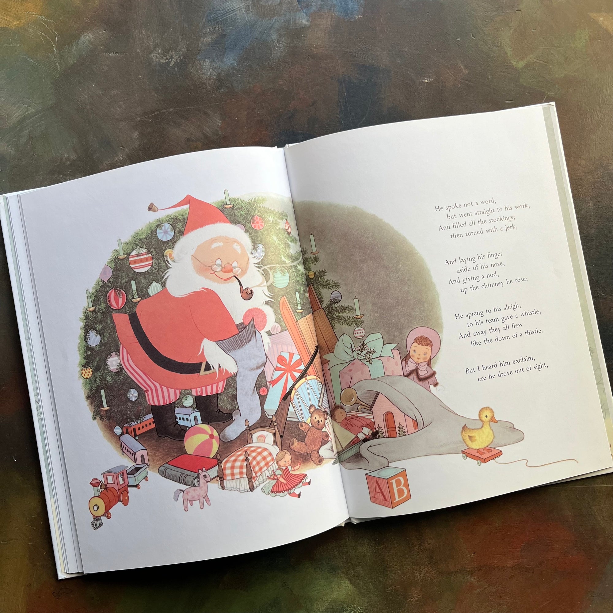 The Night Before Christmas-Clement C. Moore-Gyo Fujikawa illustrations-vintage picture book-Christmas Read Aloud-view of the illustration of Santa filling a stocking with toys from his bag