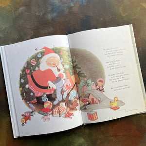 The Night Before Christmas-Clement C. Moore-Gyo Fujikawa illustrations-vintage picture book-Christmas Read Aloud-view of the illustration of Santa filling a stocking with toys from his bag