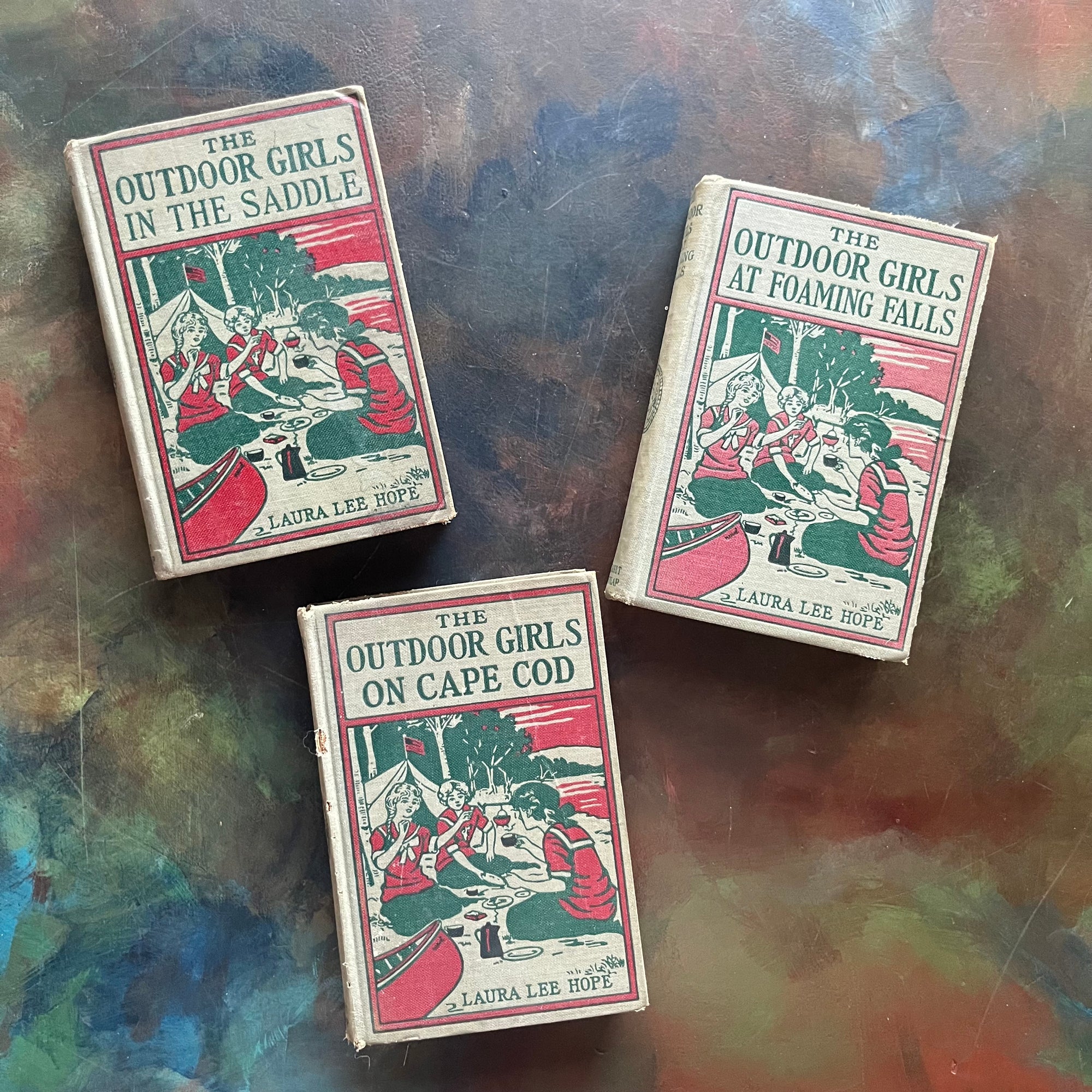 The Outdoor Girls on Cape Cod-The Outdoor Girls at Foaming Falls-The Outdoor Girls in the Saddle-Laura Lee Hope-vintage adventure books for girls-view of the embossed front covers with the same repeating image on all three covers