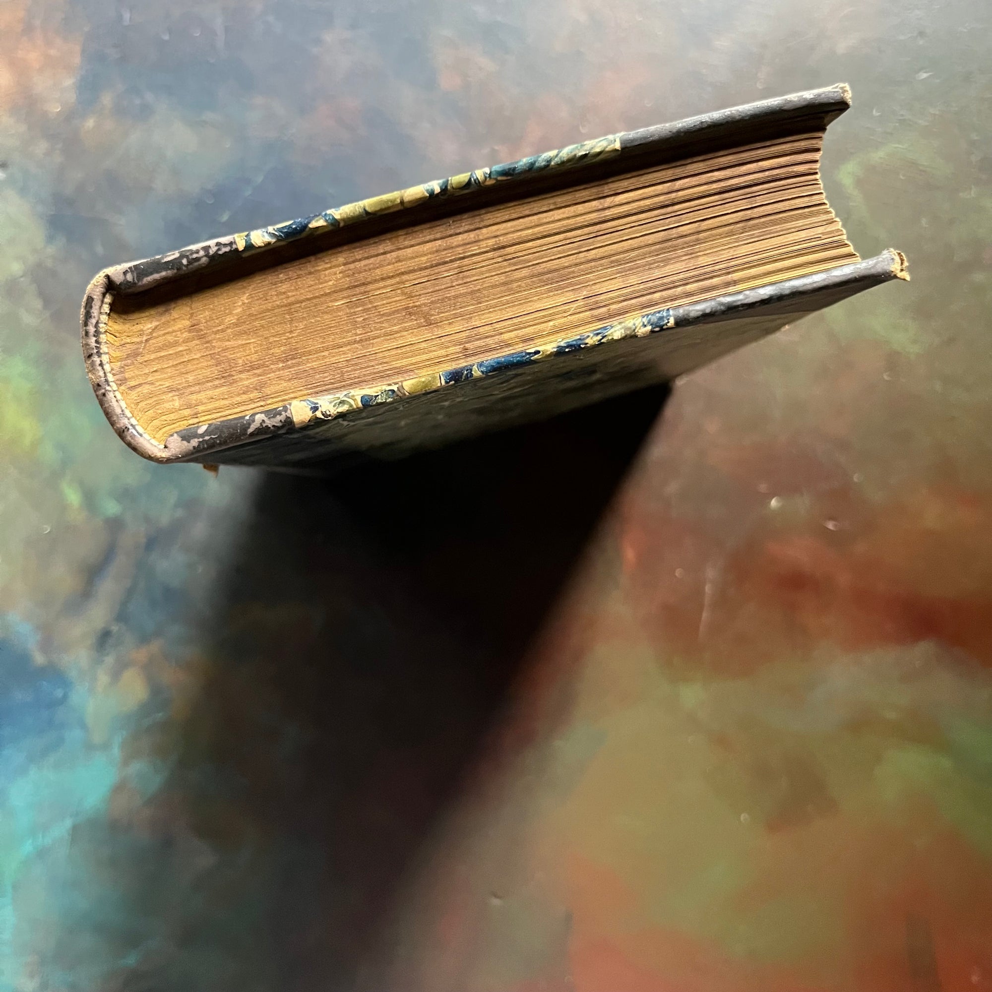 The Pioneers written by James Fenimore Cooper-book one of the leather stocking tales-antique leather-bound book with marbled cover-vintage adventure book-view of the marbled foredges