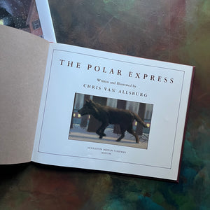 The Polar Express written and illustrated by Chris Van Allsburg-Caldecott award winning picture book-Christmas classic-view of the title page depicting an image of a wolf in the woods with the train in the background
